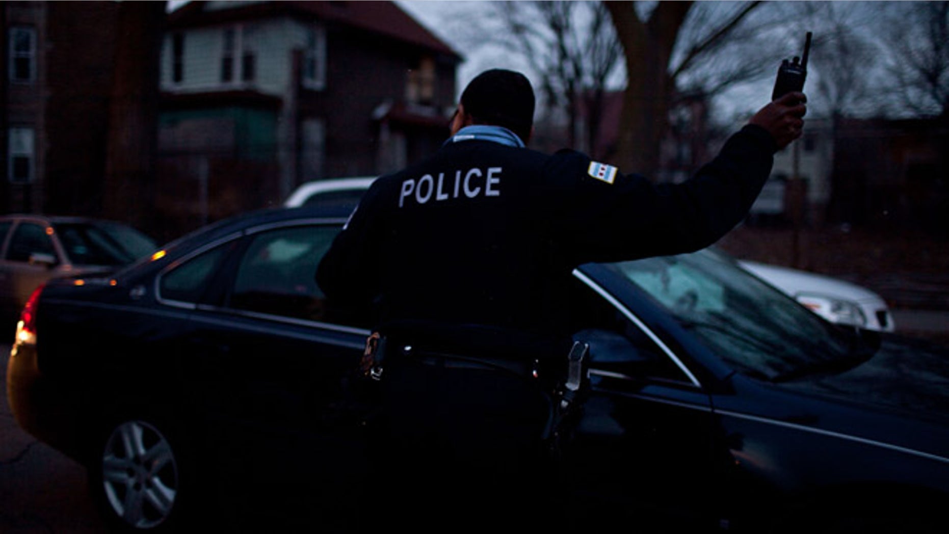CHICAGO, IL - MARCH 12: A Chicago police officer directs traffic during a vigil for slain infant Jonylah Watkins on March 12, 2013 in Chicago, Illinois. The 6-month-old girl was shot five times on the 6500 block of South Maryland Avenue while her father was changing her diaper in the passenger seat of his car. The father, Jonathan Watkins remains is stable condition at Nothwestern Memorial Hospital after receiving three gunshot wounds.(Photo by Jonathan Gibby/Getty Images)