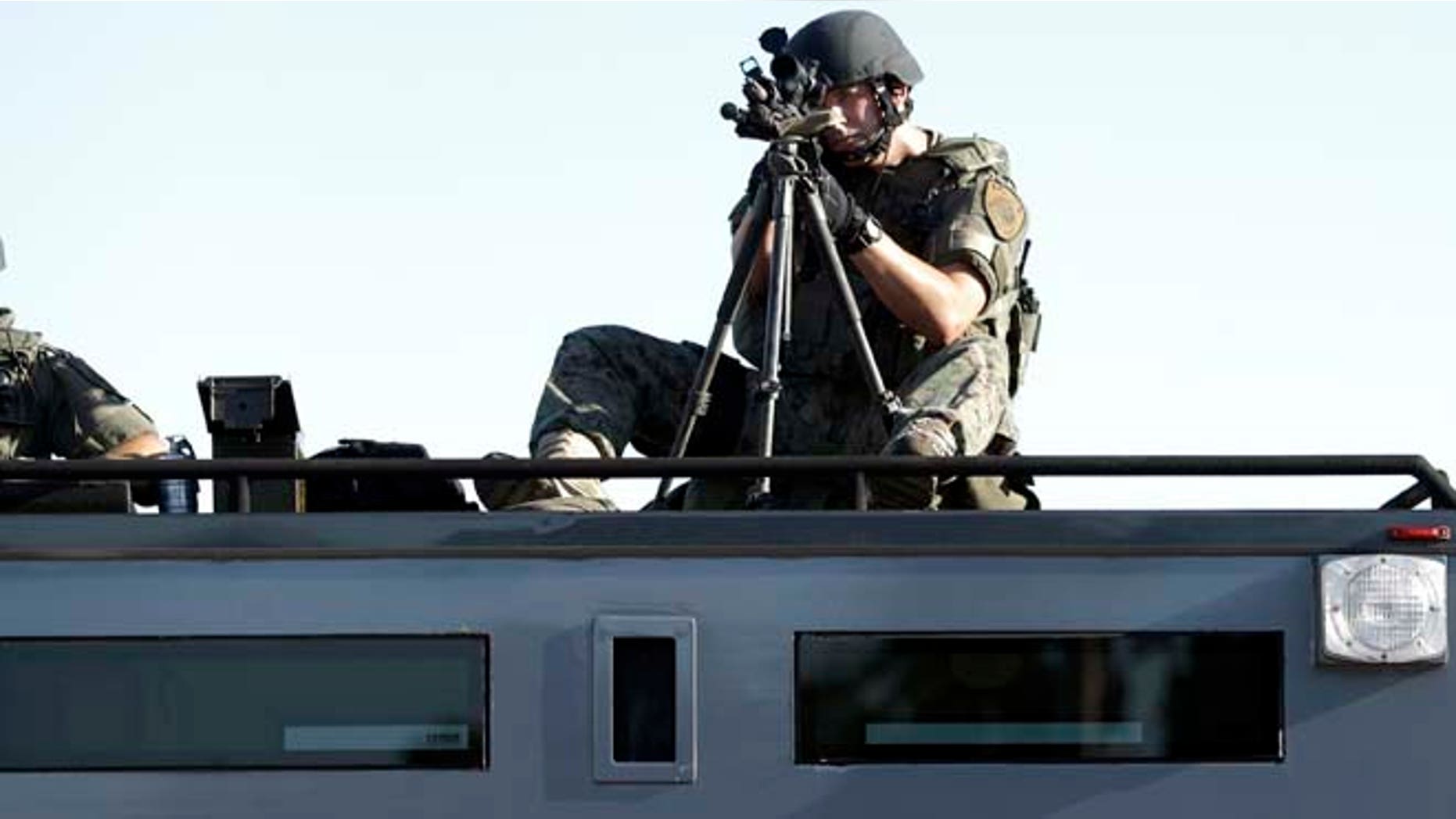 Aug. 13, 2014: A member of the St. Louis County Police Department trains his weapon on a relatively small group of protesters in Ferguson, Mo.