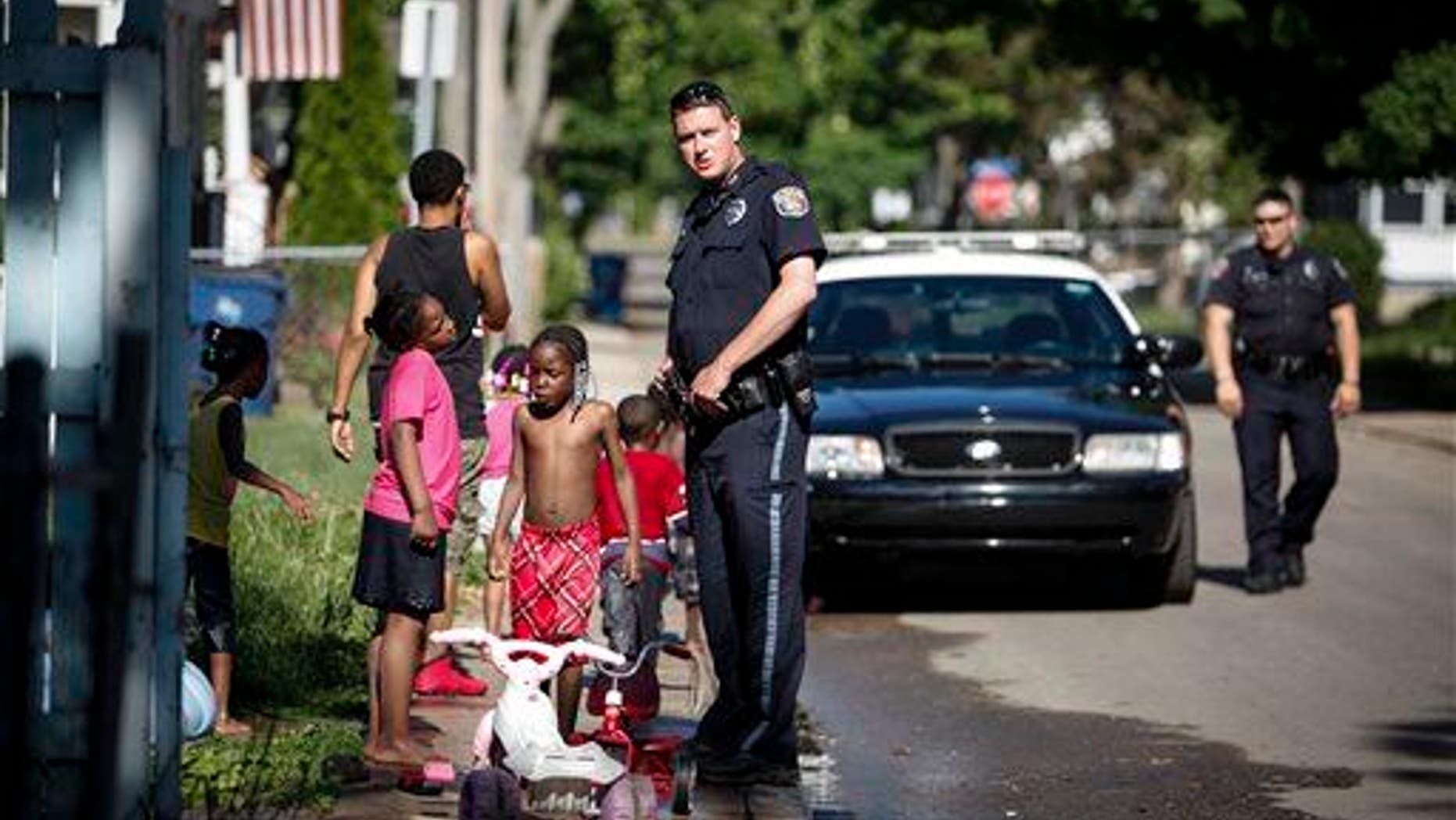 Kalamazoo Public Safety Officer Jason Gates, center, and Officer Joe Hutson, far right, stop on Hays Park Avenue in the Edison neighborhood, Friday, June 6, 2014 in Kalamazoo, Mich.