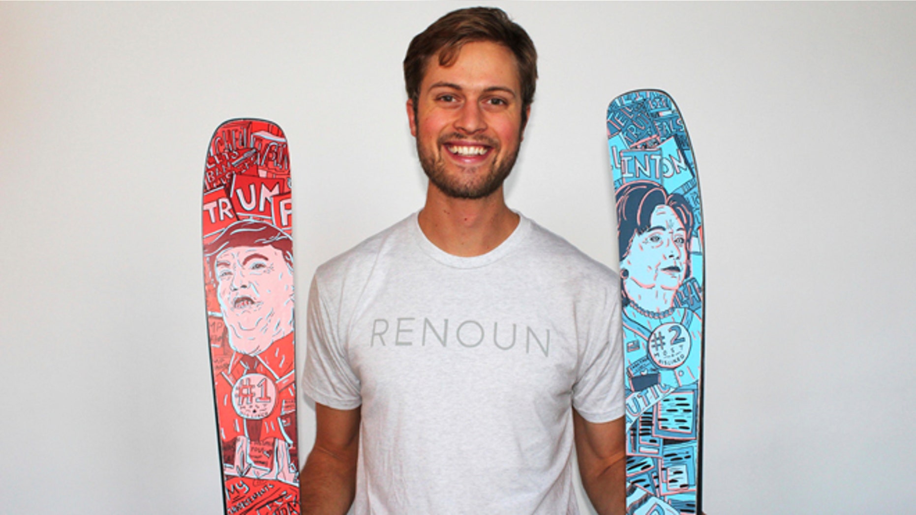 In this photo provided by Renoun, CEO Cyrus Schenck, poses with a pair of skis featuring Hillary Clinton imagery, at right, and Donald Trump, at left. (Courtesy of Renoun via AP)