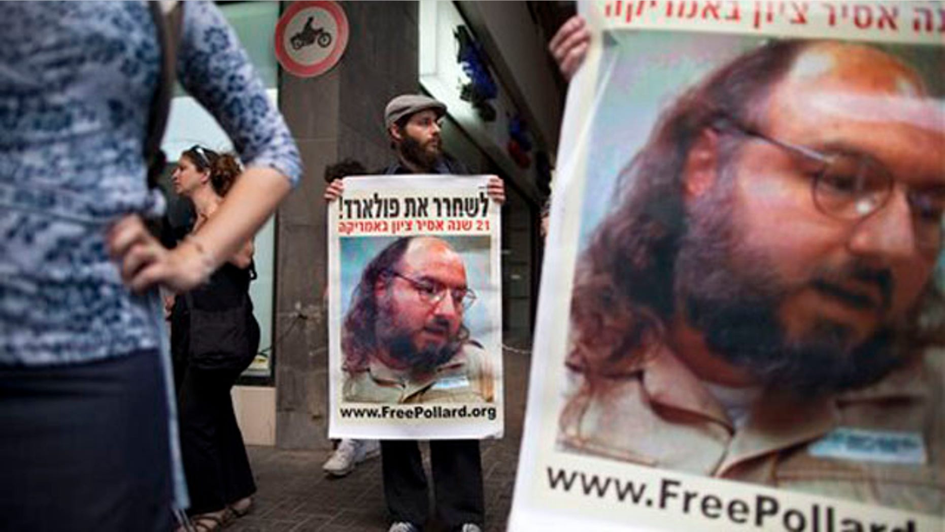 Israeli protesters hold posters demanding the release of Jonathan Pollard, a Jewish American who was jailed for life in 1987 on charges of spying on the United States, as they stand outside the U.S. embassy in Tel Aviv, Israel, Sunday, June 19, 2011. Israelis are rallying behind convicted spy Jonathan Pollard like never before, urging the U.S. on Sunday to let the former Pentagon analyst leave prison to attend his father's funeral.