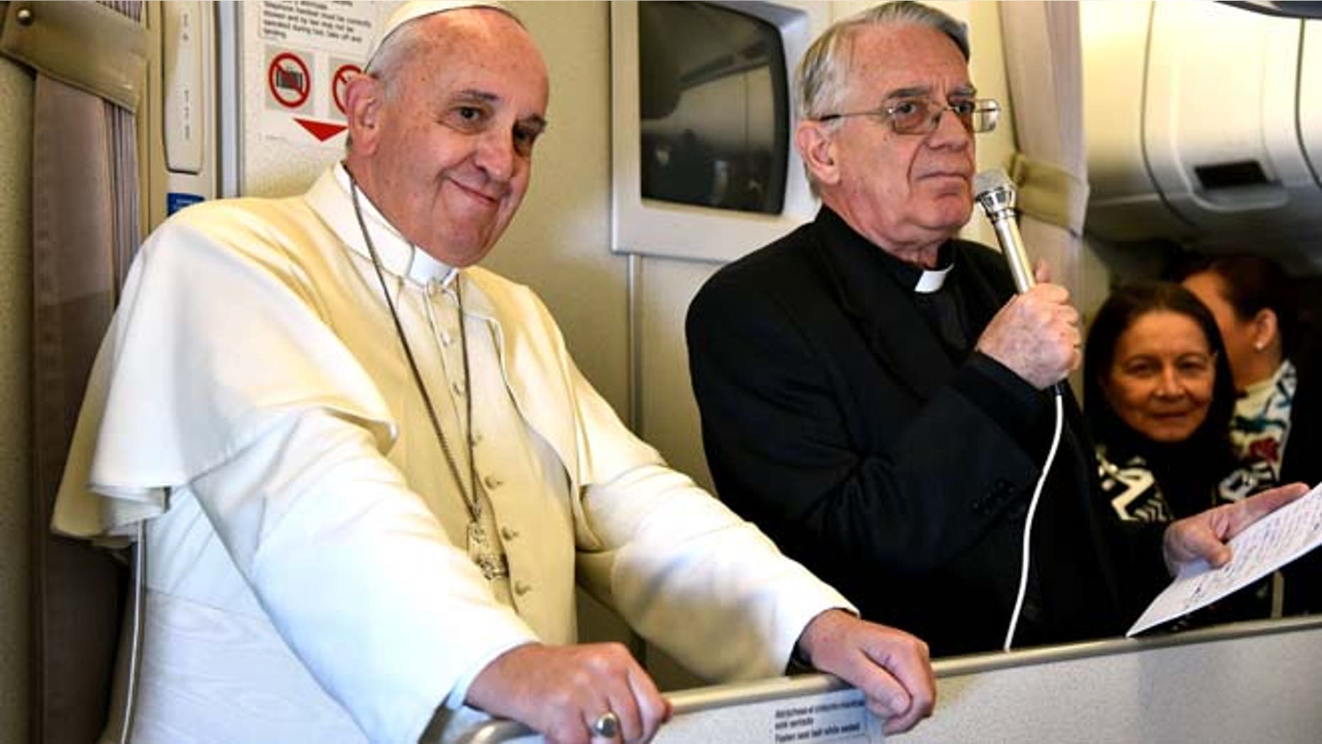 Jan. 19, 2015: Vatican spokesman Rev. Federico Lombardi, right, flanked by Pope Francis, talks with journalists during the flight from Manila to Rome. (AP/Giuseppe Cacace, pool)
