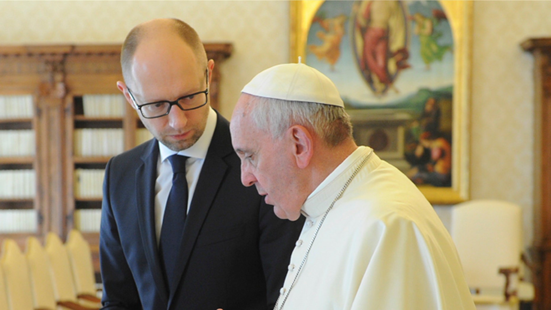 Ukrainian Prime Minister Arseny Yatsenyuk, left, listens to Pope Francis on the occasion of their private audience at the Vatican, Saturday, April 26, 2014. Yatsenyuk is in Rome to attend Sunday's canonization ceremony for John Paul II and John XXIII where Pope Francis will elevate the two popes to sainthood. (AP Photo/Andrew Kravchenko, Pool)