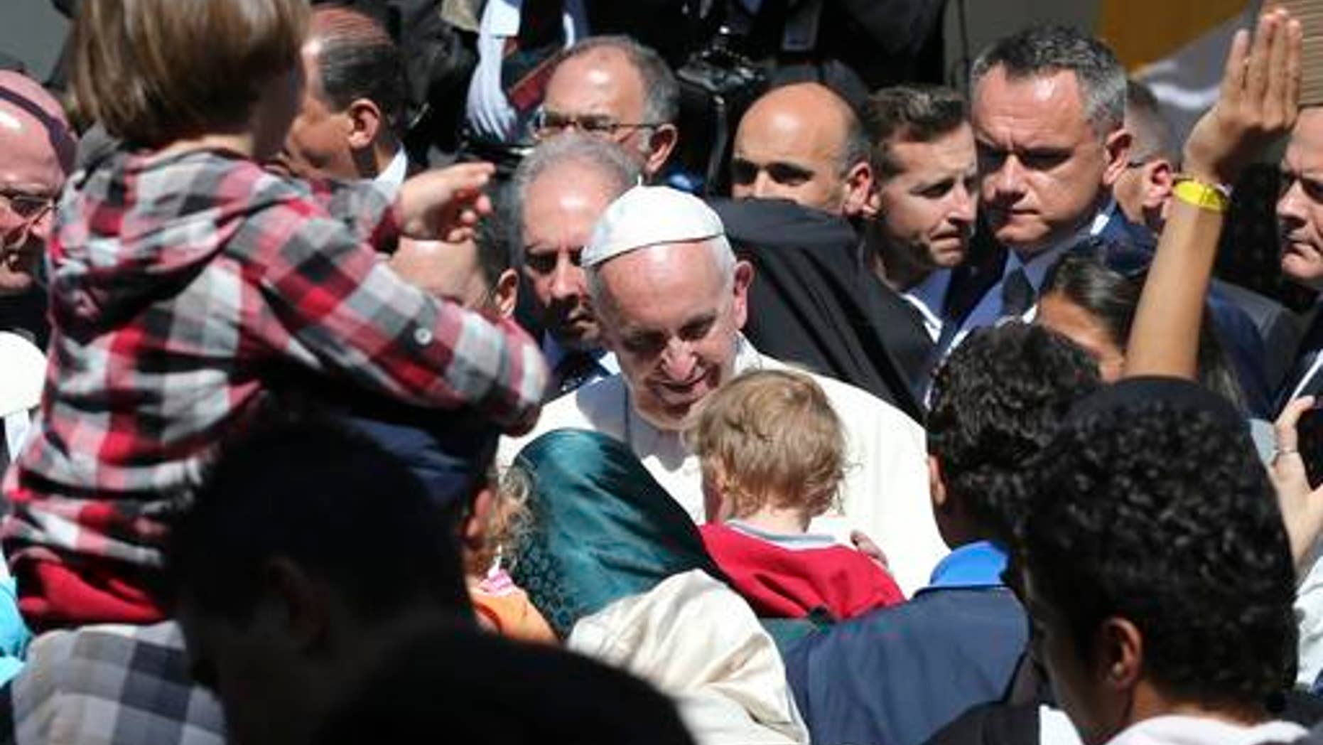 FILE - In this April 16, 2016 file photo, Pope Francis meets migrants at the Moria refugee camp on the Greek island of Lesbos. The pope, in his annual message for the World Day of Migrants and Refugees on Thursday, Oct. 13, 2016, denounced the forced repatriation of unaccompanied children migrants who flee wars and poverty, saying countries should try to meet their needs rather than return them to uncertain futures back home. (AP Photo/Petros Giannakouris, File)