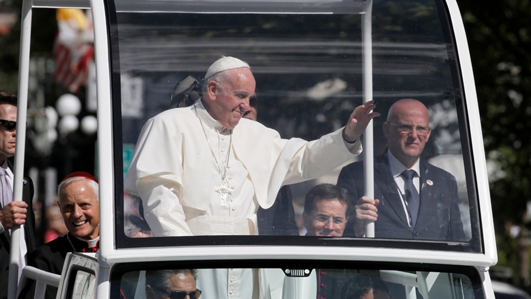 Pope Francis waves to the crowd from the popemobile during a parade in Washington, Wednesday, Sept. 23, 2015.