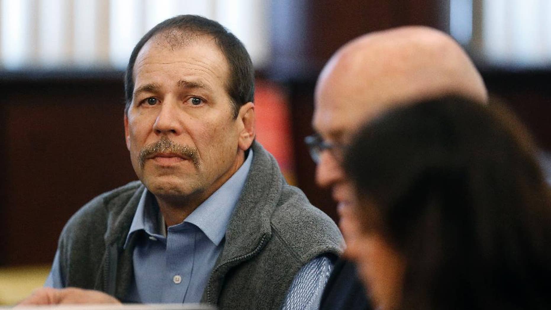 FILE - In a Dec. 18, 2013 file photo, Theodore Wafer, left, listens to his attorneys while appearing at his preliminary examination in district court in in Dearborn Heights, Mich. The 55-year-old awaits trial on second-degree murder charges for fatally shooting a young, unarmed woman through the screen door on his front porch. His lawyers are seeking to have the Wayne County Circuit Court trial judge take herself off the case because of her ties to prosecutors. A hearing is scheduled Friday, April 4, 2014. Defense attorneys say he feared for his life, but prosecutors say the shooting of Renisha McBride, 19, was not justified. (AP Photo/Paul Sancya)