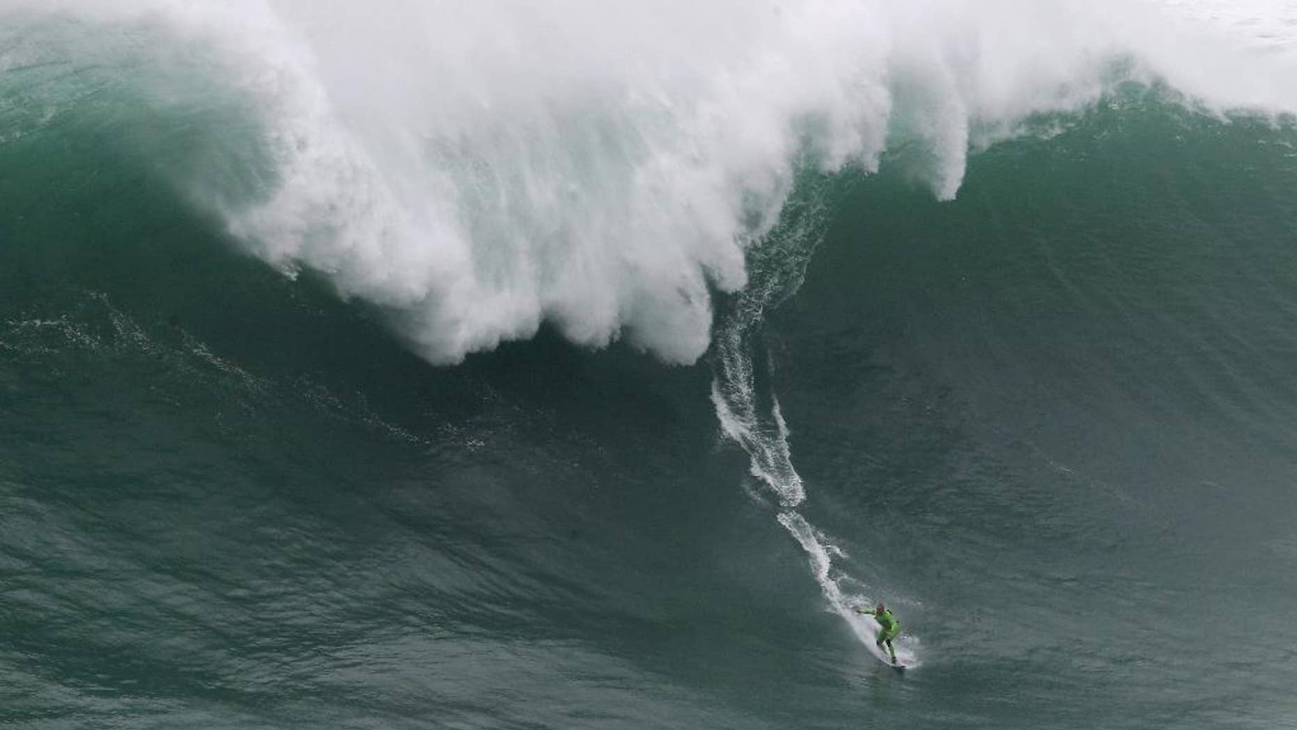 US surfer Garrett McNamara rides a big wave during a tow-in surfing session at the Praia do Norte, or North beach, in Nazare, Portugal, Sunday, Nov. 1, 2015. McNamara set a world record for the largest wave surfed when he rode a 23.7 metre wave (78-foot) in Nazare in 2011. (AP Photo/Armando Franca)