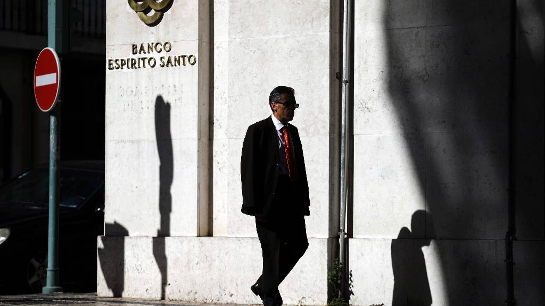 A man walks past a Portuguese bank Banco Espirito Santo's building in downtown Lisbon, Friday July 11, 2014. Senior Portuguese officials gave assurances Friday about the soundness of Portugal's biggest bank, seeking to defuse tension after world markets went into a spin over fears that Banco Espirito Santo's troubles could reignite Europe's financial difficulties. (AP Photo/Francisco Seco)