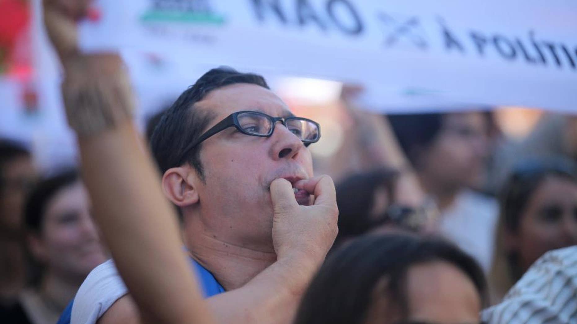 A man whistles during a workers' unions demonstration against the government's austerity measures outside the parliament in Lisbon, Wednesday, July 22 2015. On Tuesday the Portuguese president began hearing political leaders to decide on a date for the country's next general elections to be held after the summer. The banner reads "No to right wing policy". (AP Photo/Armando Franca)