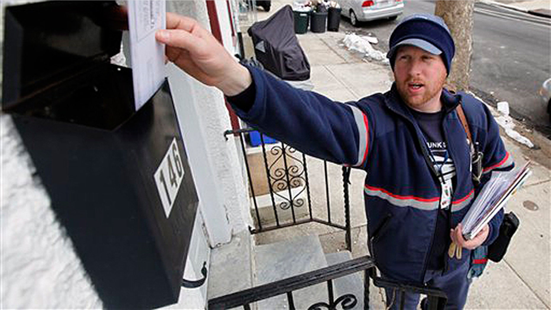 FILE - March 2, 2010: Letter carrier Kevin Pownall delivers mail in Philadelphia.
