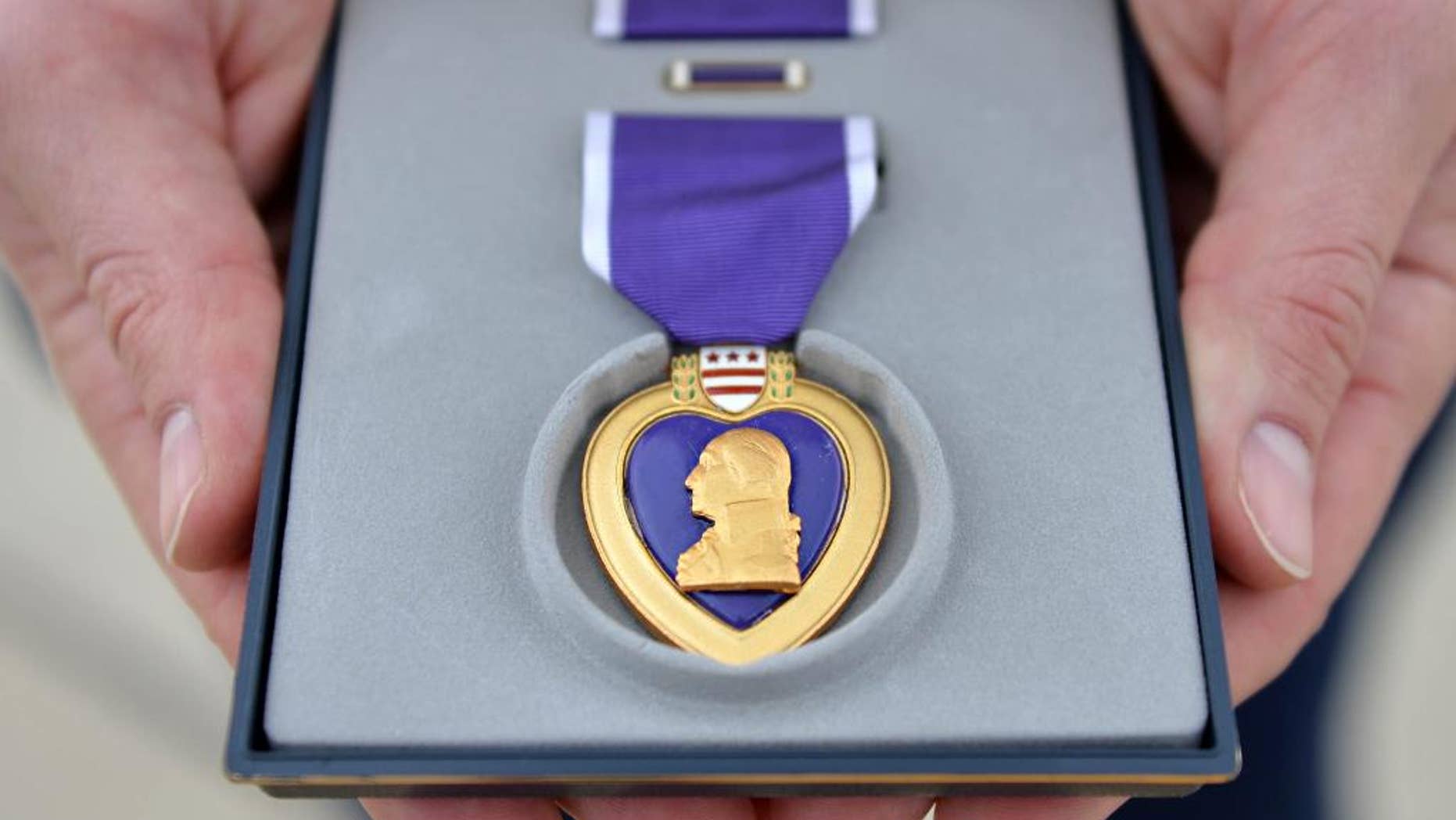 Lorraine Manatt, the daughter of a survivor of the shooting down of Army Air Force B-17 ``Lady Jane II'' bomber over Berlin near the end of World War II, receives a Purple Heart awarded postumously to her father, Sgt. Rodney A. Williams, during a ceremony at Los Alamitos Army Airfield in Los Alamitos, Calif., Wednesday, March 18, 2015, exactly 70 years to the date that he and eight others were shot down. (AP Photo/Daily Breeze, Brittany Murray)