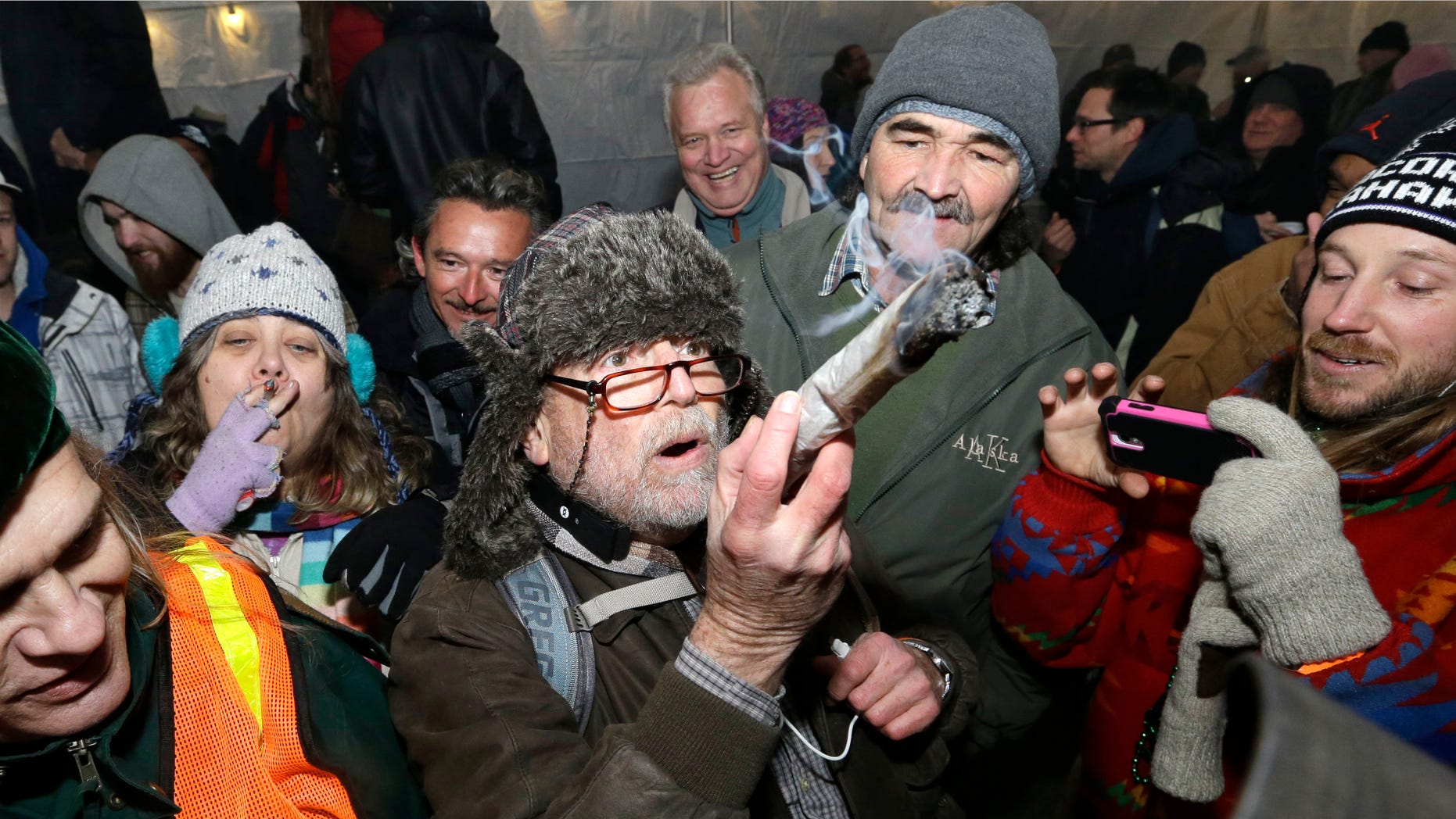 Dec. 6, 2013: A partier looks over a marijuana joint, made from a full ounce of pot, before taking a hit on it at a pot party at the Seattle Center, in Seattle.