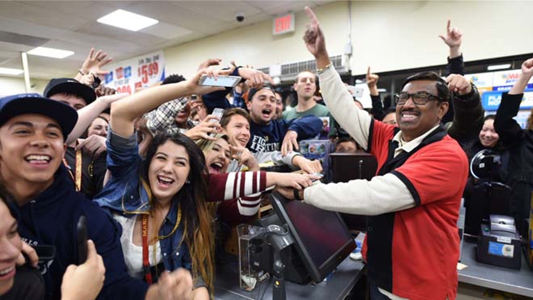 7-Eleven store clerk M. Faroqui celebrates with customers after learning the store sold a winning Powerball ticket on Wednesday, Jan. 13, 2016 in Chino Hills, Calif. One winning ticket was sold at the store located in suburban Los Angeles said Alex Traverso, a spokesman for California lottery. The identity of the winner is not yet known. (Will Lester/The Sun via AP) MANDATORY CREDIT