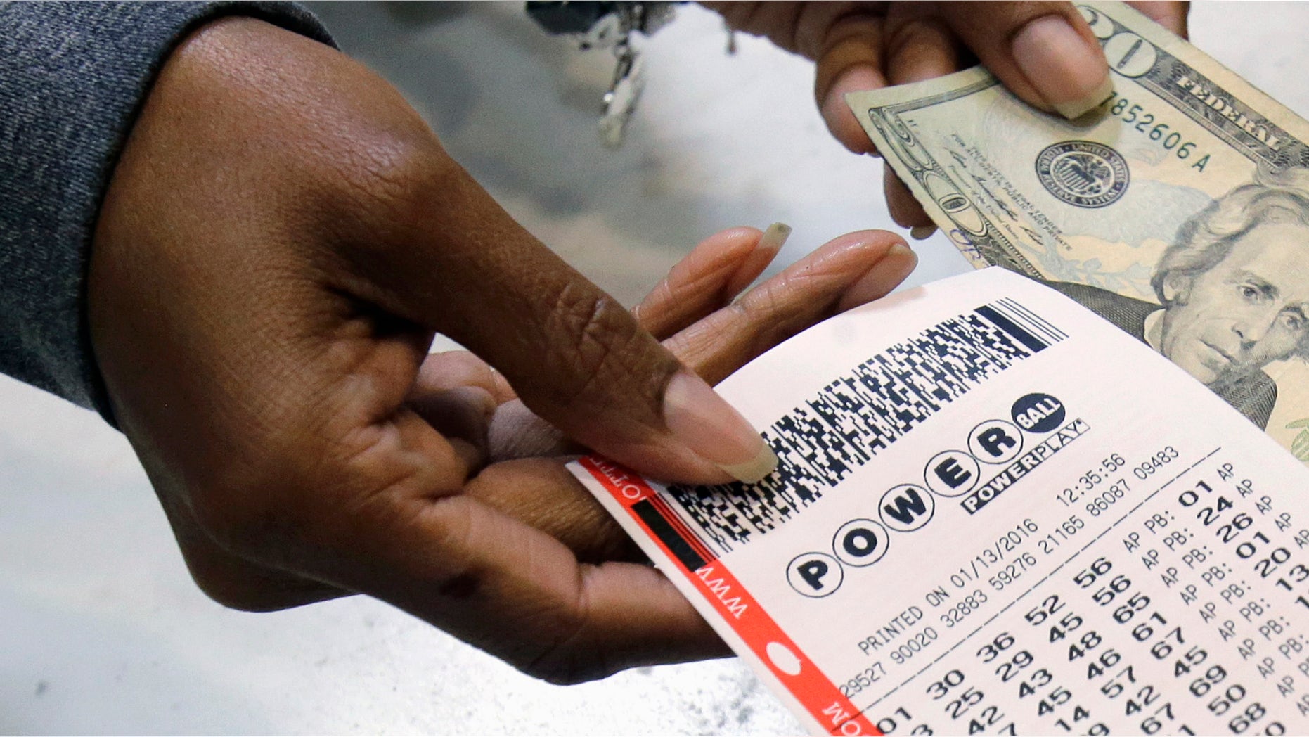 FILE - In this Jan. 13, 2016 file photo, a clerk hands over a Powerball ticket for cash at Tower City Lottery Stop in Cleveland. Powerball estimates that its jackpot for the May 4, 2016, drawing is $348 million. (AP Photo/Tony Dejak, File)
