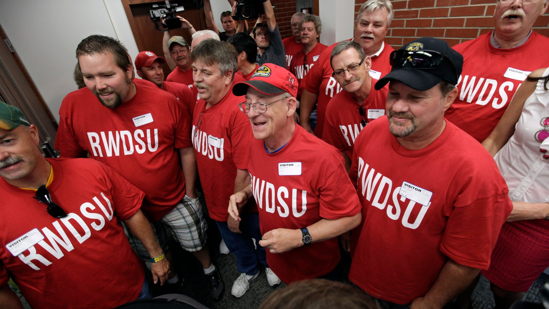 June 20, 2012: Workers from the Quaker Oats plant in Cedar Rapids, Iowa, look on as their winning $241 million Powerball ticket is scanned at the Iowa Lottery headquarters in Des Moines, Iowa.