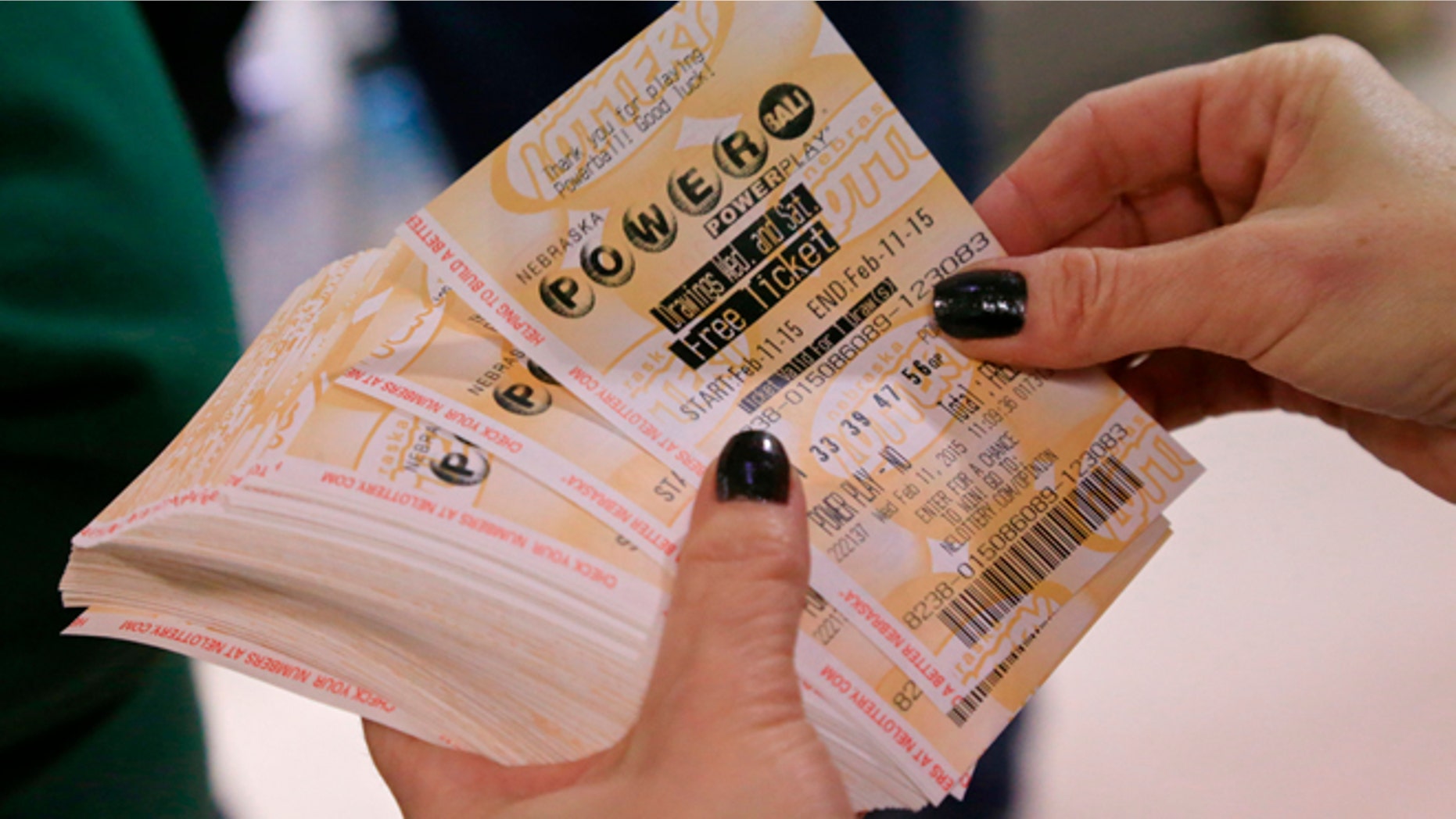 A lottery representative hands out free Powerball tickets at Russ's Market in Lincoln, Neb., as part of a promotion, Wednesday, Feb. 11, 2015. The Powerball jackpot has climbed to an estimated $500 million, which would make it the fifth largest lottery prize in U.S. history.