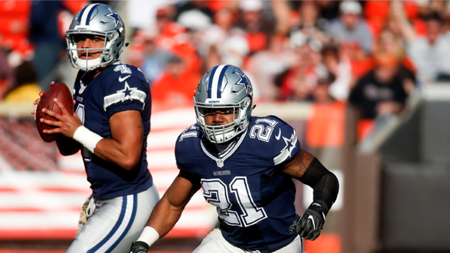 Dallas Cowboys running back Ezekiel Elliott (21) runs on a play as quarterback Dak Prescott (4) looks to pass in the second half of an NFL football game against the Cleveland Browns, Sunday, Nov. 6, 2016, in Cleveland. (AP Photo/Ron Schwane)
