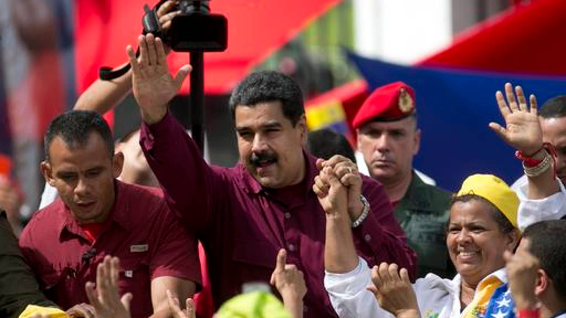 Venezuela's President Nicolas Maduro waves to supporters during a rally outside Miraflores presidential palace in Caracas, Venezuela, Friday, Oct. 28, 2016. For the most part, residents of Venezuela's capital ignored calls to stay home Friday to protest Maduro, handing a rare victory to the embattled leader. (AP Photo/Ariana Cubillos)