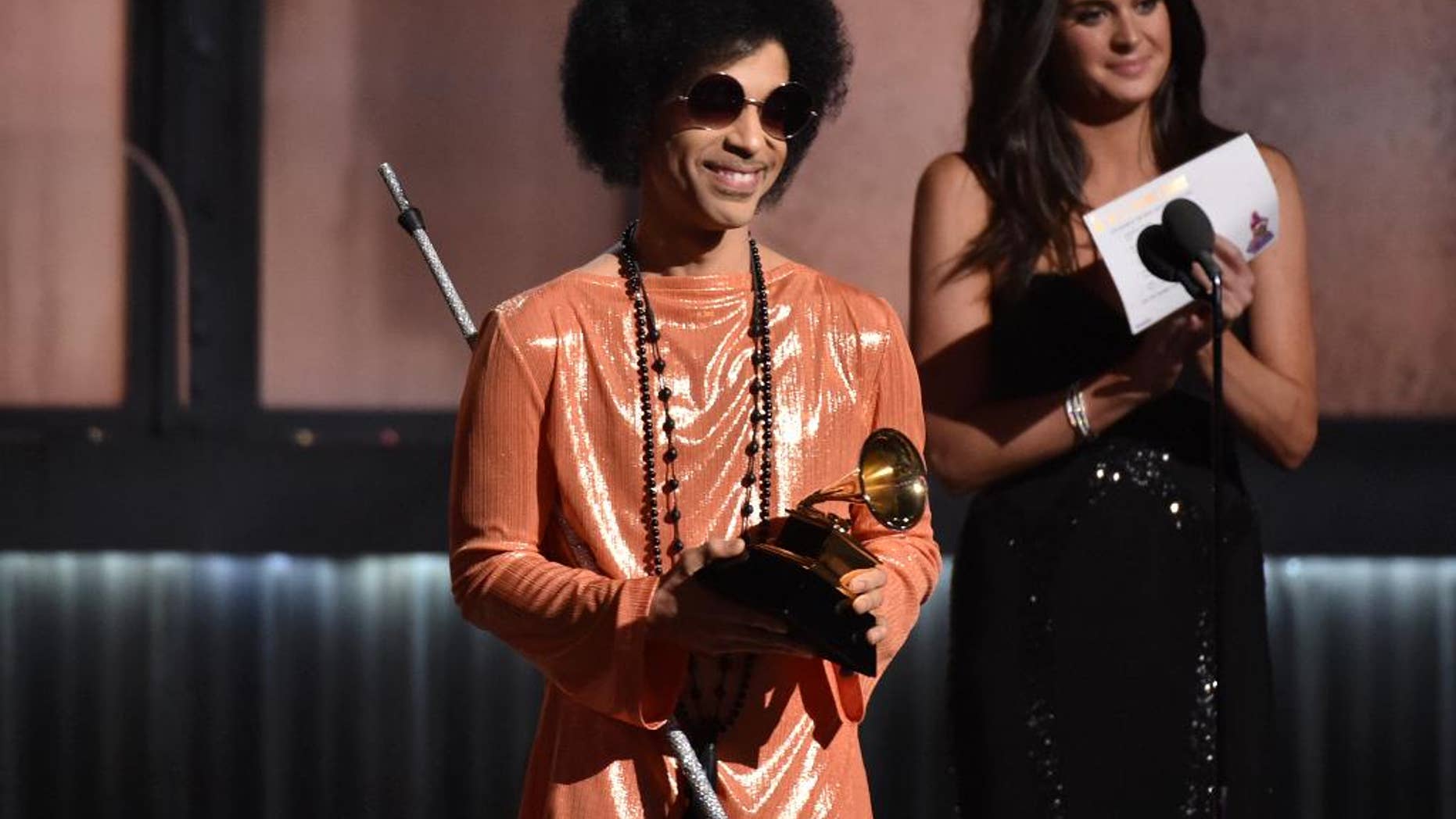 FILE - In this Feb. 8, 2015 file photo, Prince presents the award for album of the year at the 57th annual Grammy Awards in Los Angeles. Prince has announced plans to perform at a concert in Baltimore following recent unrest in the city over the death of a man who was fatally injured in police custody. A statement issued Tuesday, May 5, 2015, says the pop icon will perform Sunday, May 10, at “Rally 4 Peace,” a concert at the Royal Farms Arena in Baltimore. (Photo by John Shearer/Invision/AP)