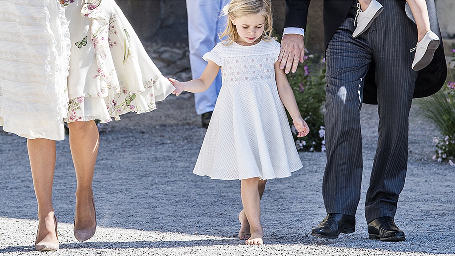 A barefoot Princess Leonore walks along side of her parents at the traditional christening ceremony for her sister, Princess Adrienne.