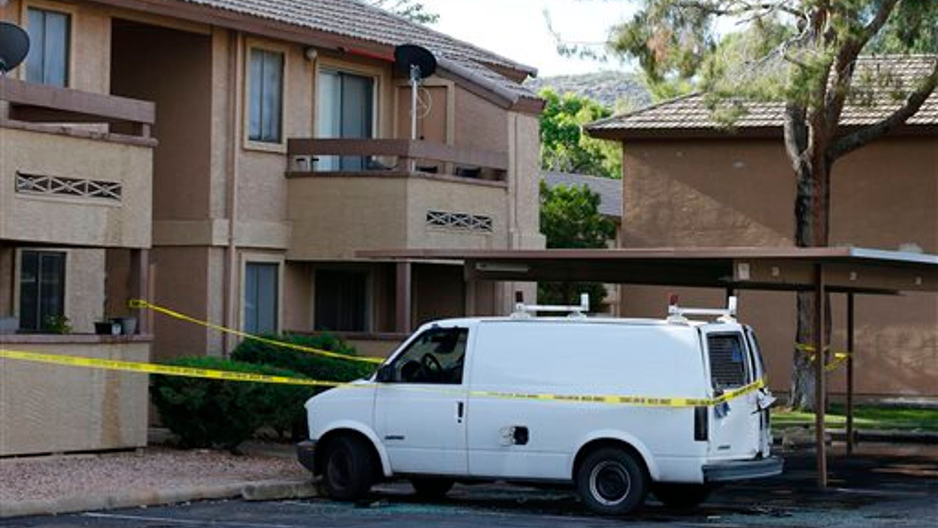 Police tape surrounds a vehicle searched by authorities, Monday, May 4, 2015, in Phoenix, believed to belong to one of two gunmen who were shot and killed the night before outside a venue hosting an exhibit about the Prophet Muhammad in suburban Dallas. Garland, Texas, police officer Joe Harn says the men had opened fire with assault rifles, and that one officer had fatally shot both gunmen. (AP Photo/Ross D. Franklin)