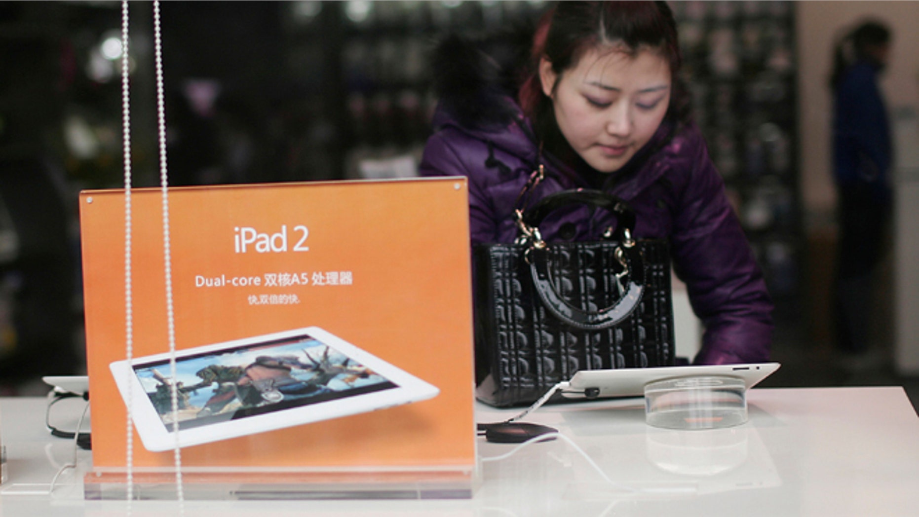 Feb. 27, 2012: A customer tries out Apple's iPad 2 at a retail shop in Chongqing, China. The Taiwan-based maker Proview Electronics said Monday it is now seeking to regain worldwide rights to the iPad name and is suing Apple Inc. for alleged fraud and unfair competition.
