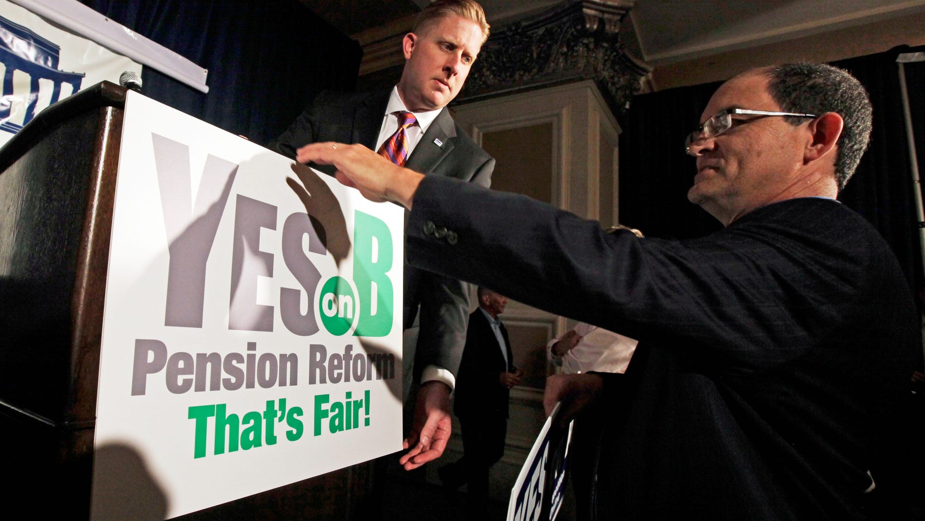 June 5, 2012: Supporters of Proposition B, which would roll back public pensions, adjust a sign before a rally on election day in San Diego in this file photo.