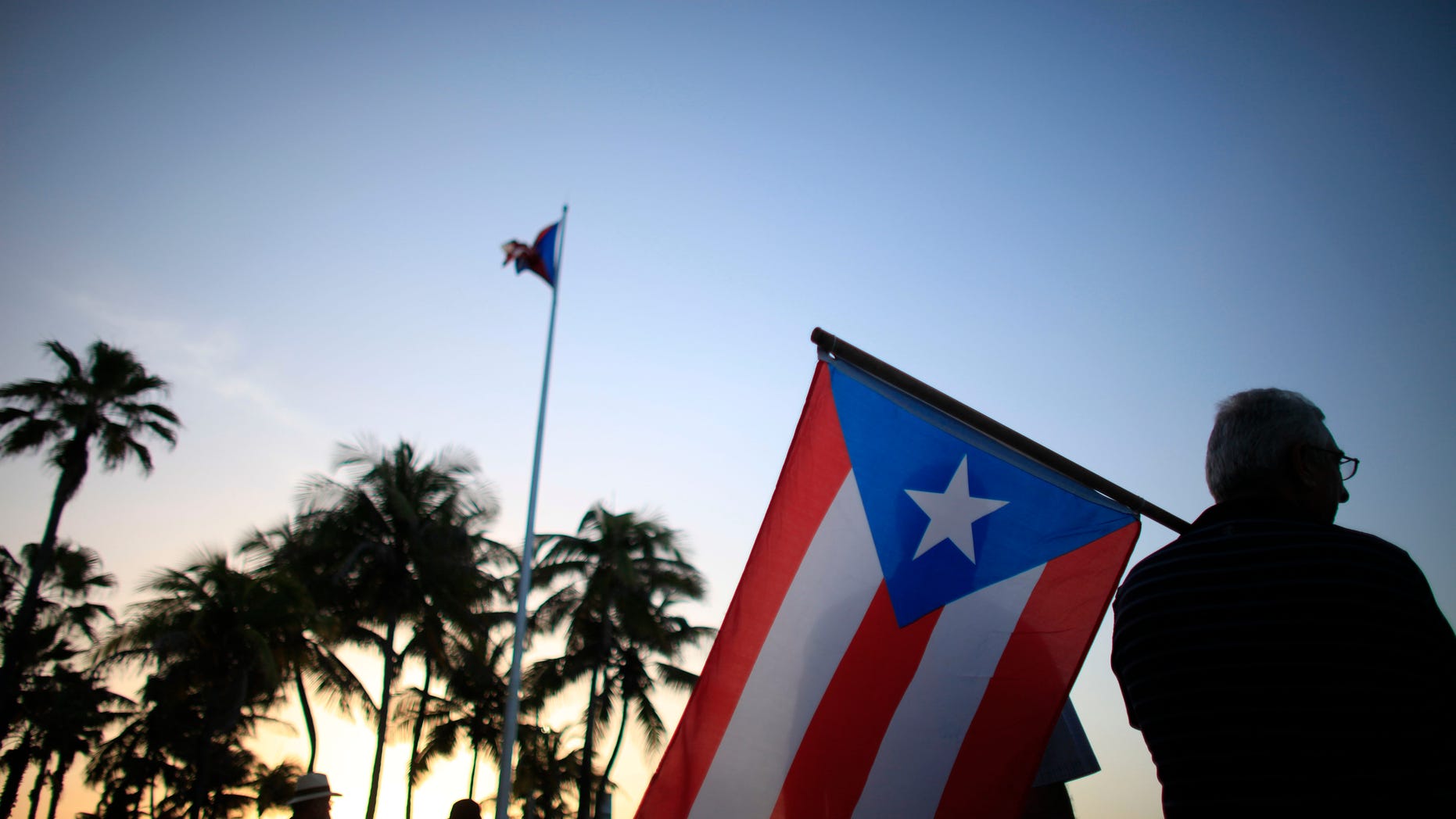 FILE - In this April 30, 2015, file photo, people gather in front of the Puerto Ricos Capitol building to protest against Gov. Alejandro Garcia Padilla's budget proposal for the next fiscal year in San Juan. Puerto Rico's electric utility says its been given a brief reprieve for approval of a debt restructuring deal. The Puerto Rico Electric Power Authority says bondholders and bank lenders agreed to extend Fridays deadline to Tuesday, Dec. 22, 2015, to win approval from bond insurers.(AP Photo/Ricardo Arduengo, File)