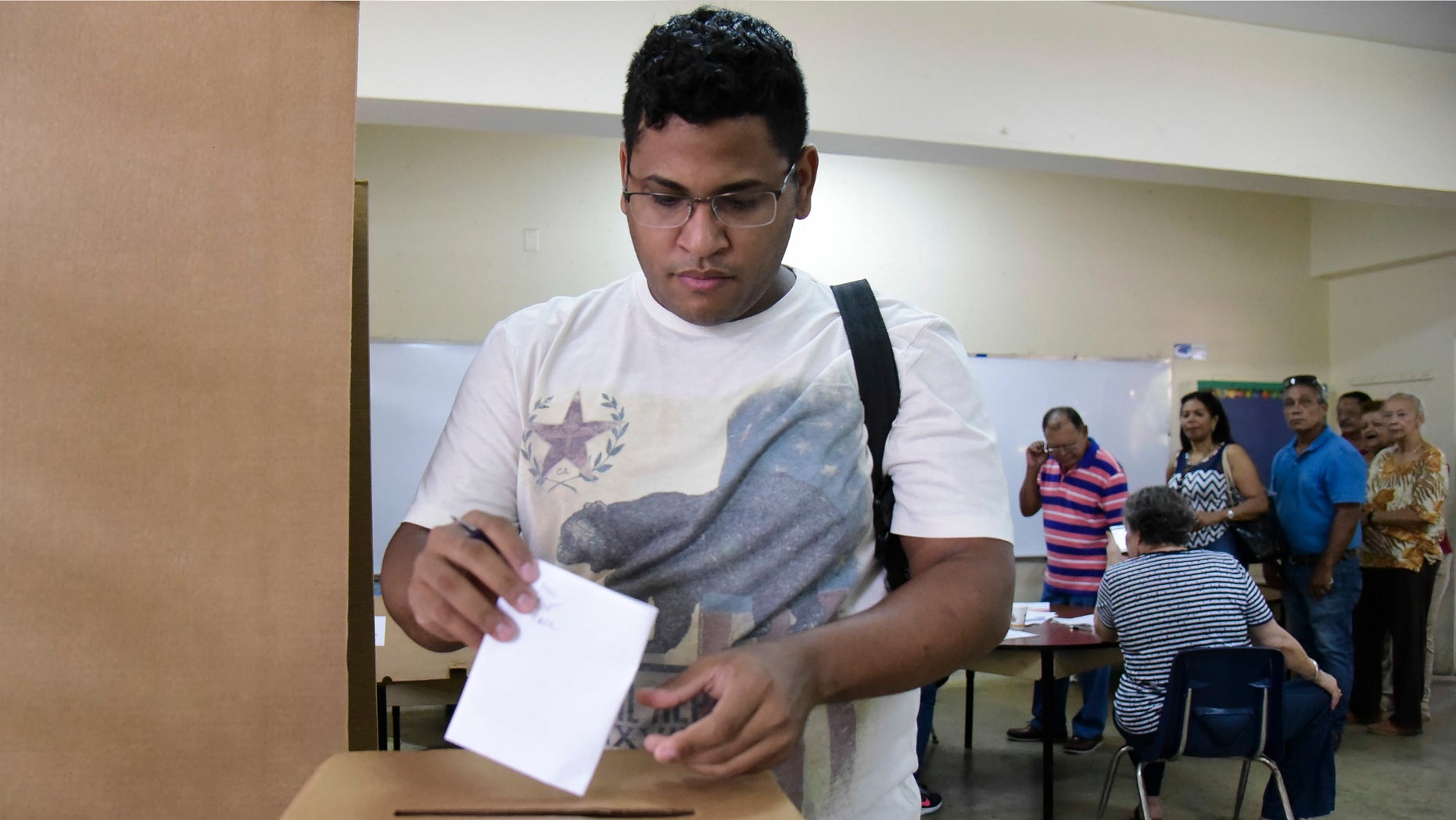 Puerto Rico resident Hector Feliciano votes during the U.S. territory's Democratic primary election at the Luis Llorens Torres Elementary School in San Juan, Puerto Rico, Sunday June 5, 2016 . Puerto Ricans frustrated by island's economic crisis are voting in the U.S. territory's Democratic presidential primary, as front-runner Hillary Clinton draws closer to securing the number of delegates needed to win her party's nomination. (AP Photo/Carlos Giusti)