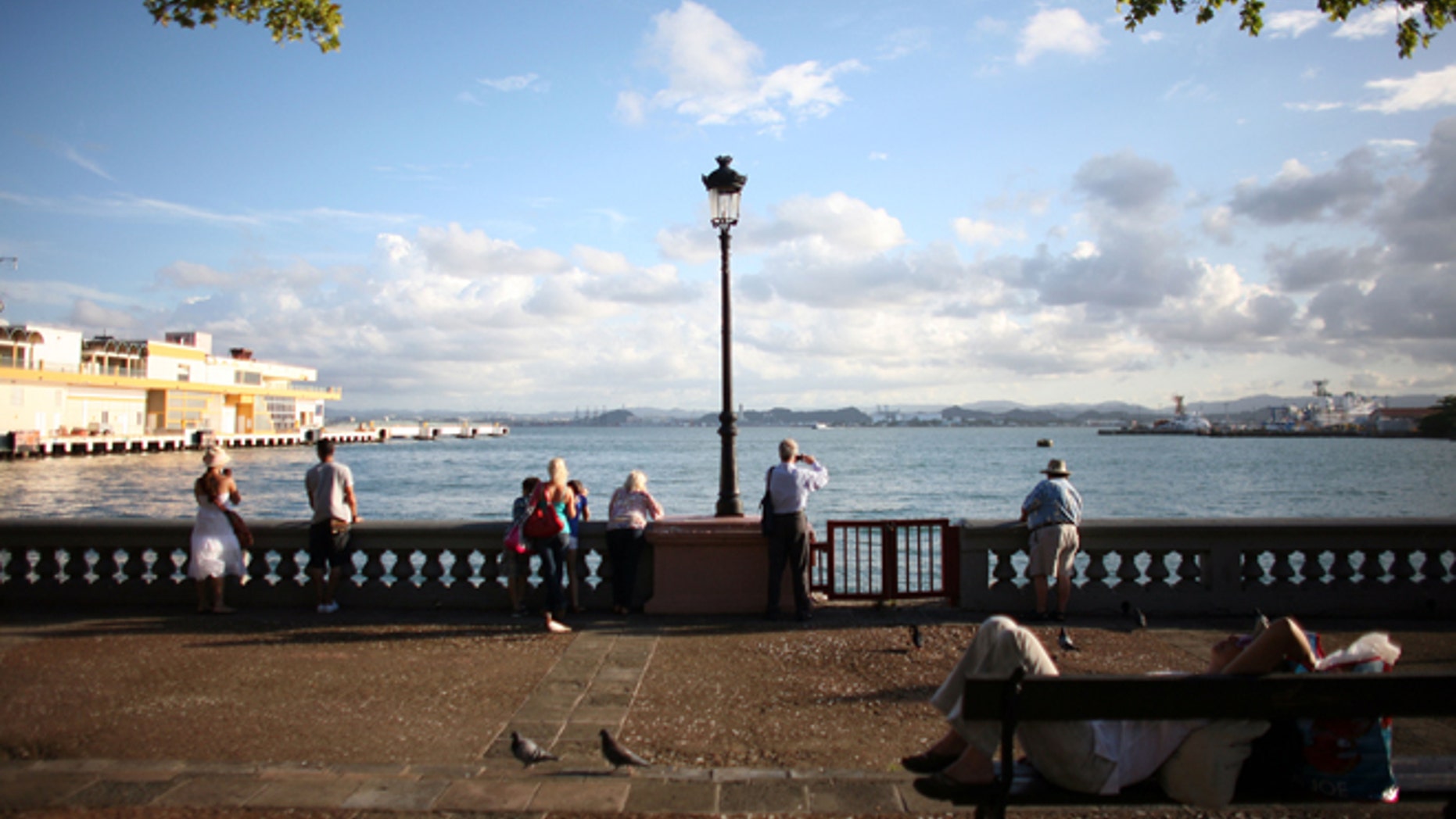 FILE - In this Nov. 23, 2011 file photo, tourists look out from the pier near the cruise ship terminal in Old San Juan, Puerto Rico. The Caribbean country is launching a two-day summit starting Thursday, April 24, 2014 to lure wealthy investors to the U.S. territory as it struggles to emerge from a nearly eight-year recession. (AP Photo/Ricardo Arduengo, File)