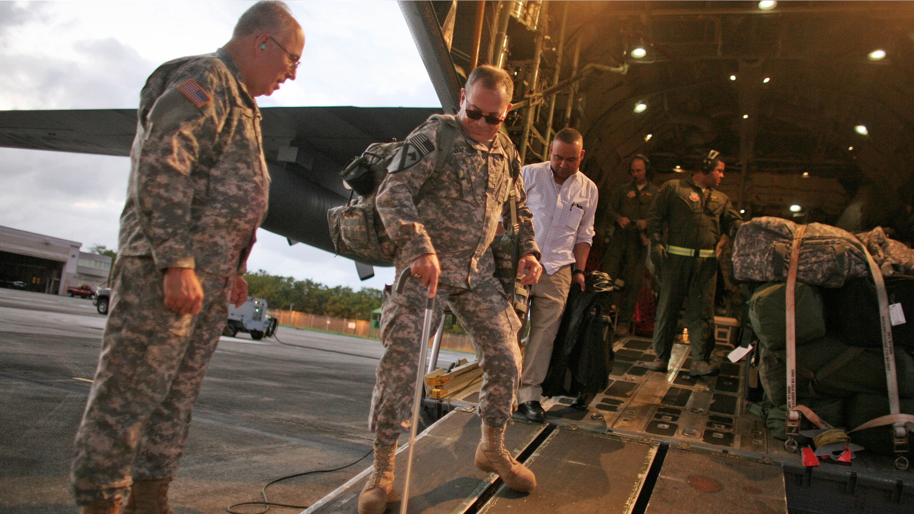 U.S. Army Chief Warrant Officer Diaz-Rivera, center, arrives to San Juan, Puerto Rico, Tuesday, Dec. 20, 2011. Puerto Rico National Guard officials say they flew home some 20 soldiers for a short break from their medical treatment. Maj. Gen. Antonio Vicens says some time at home with their families will help them recover from wounds sustained in Afghanistan, Iraq and elsewhere. (AP Photo/Ricardo Arduengo)