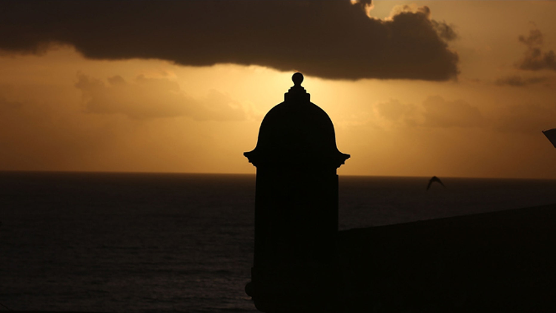 SAN JUAN, PUERTO RICO - JUNE 30: The sun rises near a guard tower at Fort San Felipe del Morro a day after Puerto Rican Governor Alejandro Garcia Padilla gave a speech regarding the government's $72 billion debt on June 30, 2015 in San Juan, Puerto Rico. The Governor said in his speech that the people will have to sacrifice and share in the responsibilities for pulling the island out of debt. (Photo by Joe Raedle/Getty Images)