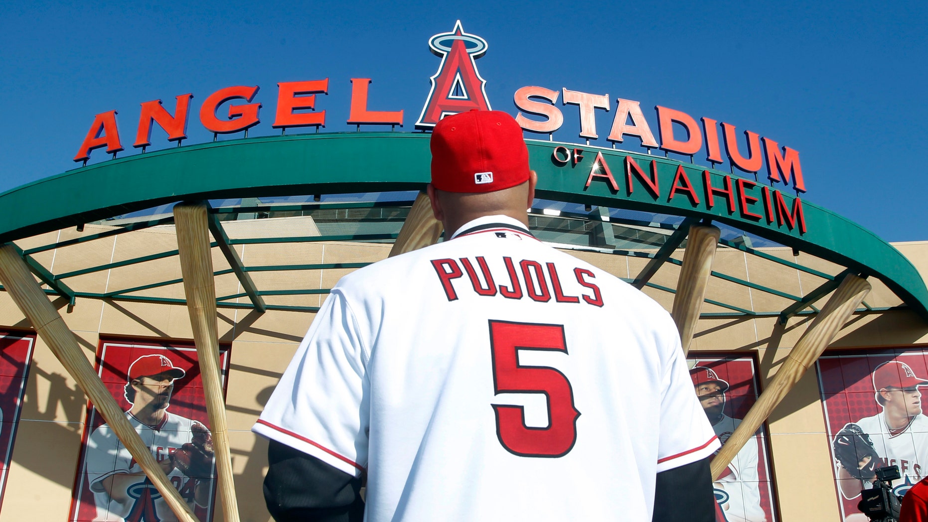 CORRECTS DATE - Los Angeles Angels' Albert Pujols wears his new jersey after a baseball news conference in Anaheim, Calif., Saturday, Dec. 10, 2011. Pujols and the Angels agreed to a landmark 10-year, $254 million deal. (AP Photo/Alex Gallardo)