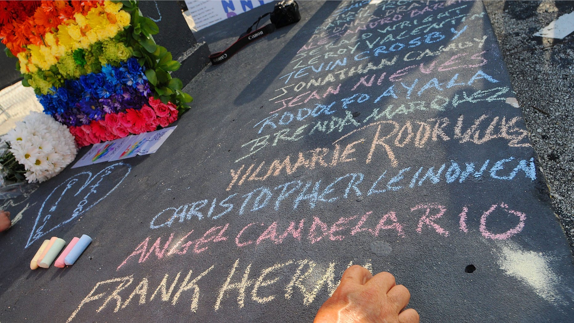 Edwin Rodriguez writes the names of the victims of the Pulse Nightclub shooting at the front of the nightclub building on June 21, 2016 in Orlando, Florida. The Orlando community continues to mourn the June 12 shooting at the Pulse nightclub in what is being called the worst mass shooting in American history, Omar Mir Seddique Mateen killed 49 people at the popular gay nightclub early last Sunday. Fifty-three people were wounded in the attack which authorities and community leaders are still trying to come to terms with. (Photo by Gerardo Mora/Getty Images)