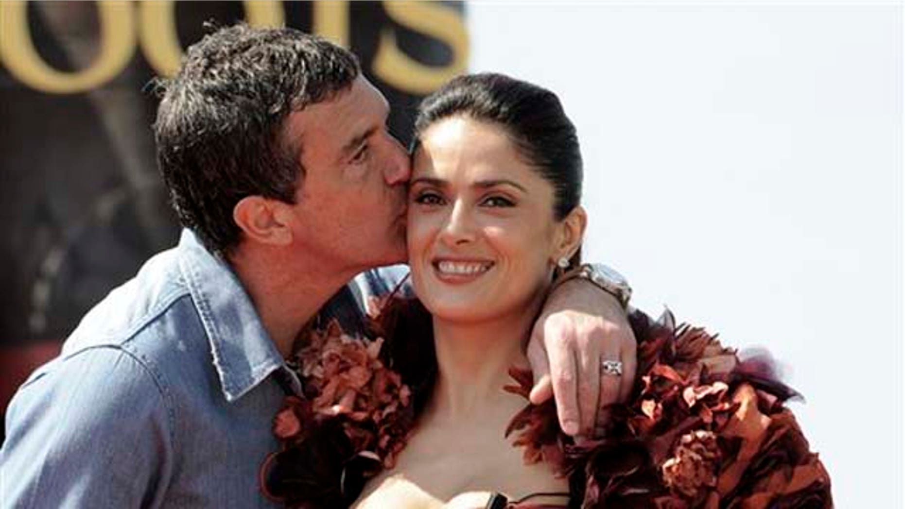 Actor Antonio Banderas, left, kisses actress Salma Hayek on the cheek during a photo call for Puss in Boots, at the 64th international film festival, in Cannes, southern France, Wednesday, May 11, 2011. (AP Photo/Jonathan Short)