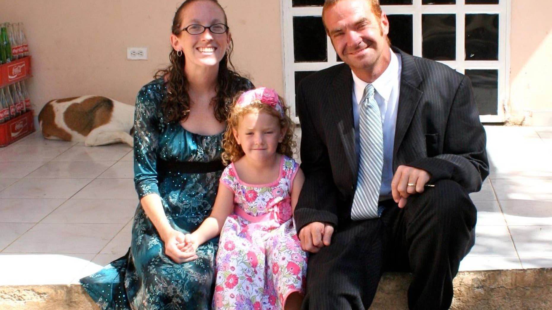 Leann and Daniel Pye sit with their 4-year-old daughter Riann in front of their orphanage in Jacmel, Haiti.