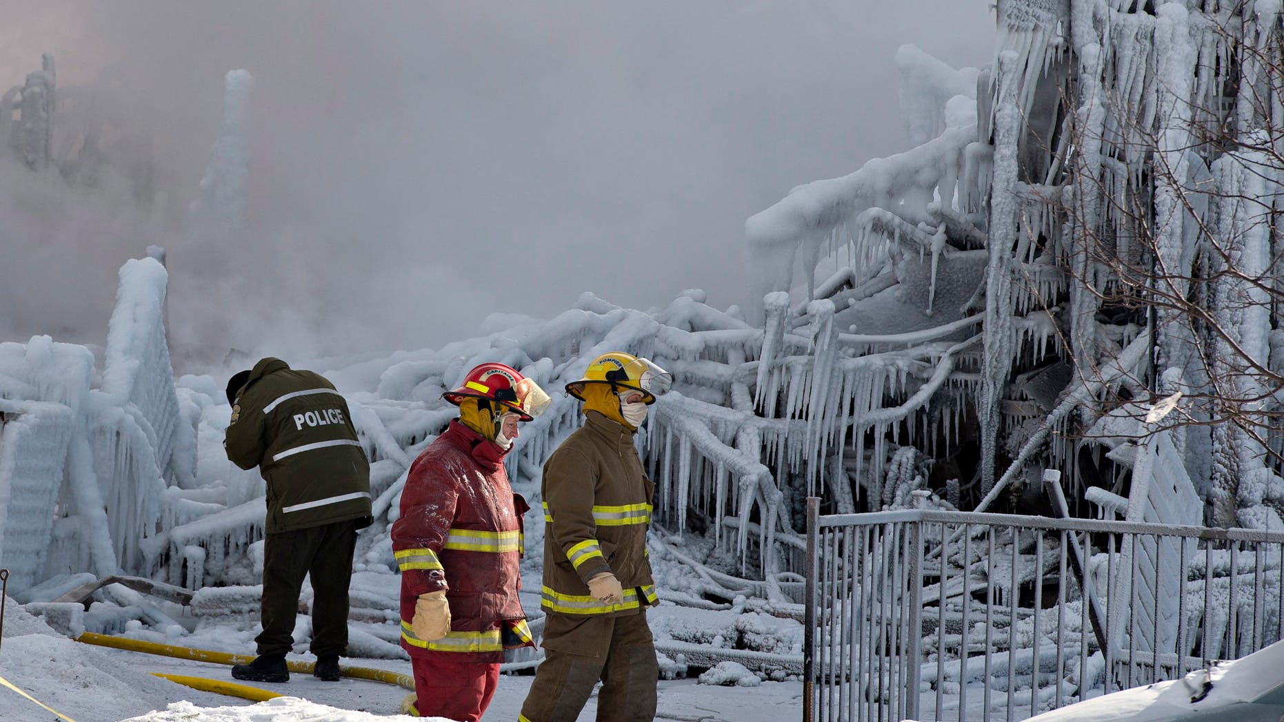 Jan. 23, 2014 - Police and firefighters survey the damage after a fatal fire at a seniors residence in L'Isle-Verte, Quebec. The fire raged through the seniors residence, killing at least 5 people and leaving about 30 unaccounted for.