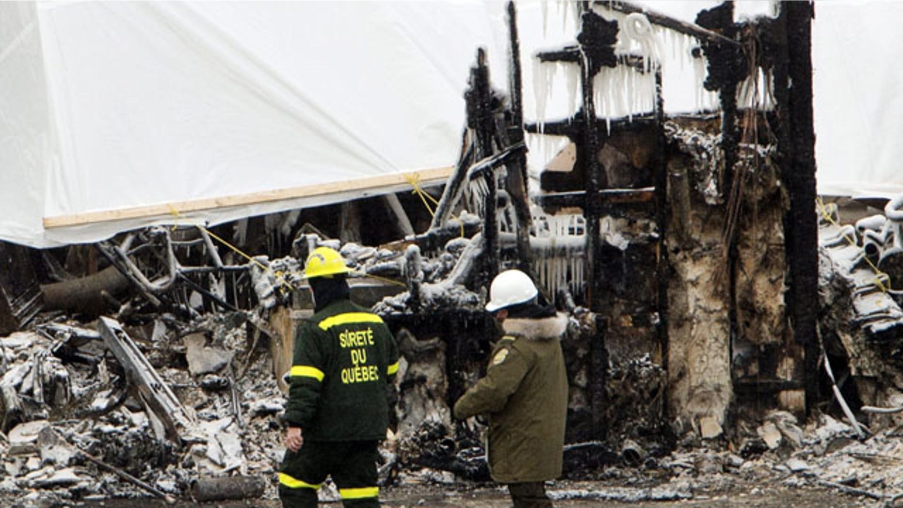 January 25, 2014: Emergency workers continue the search for victims in L'Isle-Verte, Quebec, at the scene of Thursday's fatal fire at a seniors residence. (AP Photo/The Canadian Press, Ryan Remiorz)