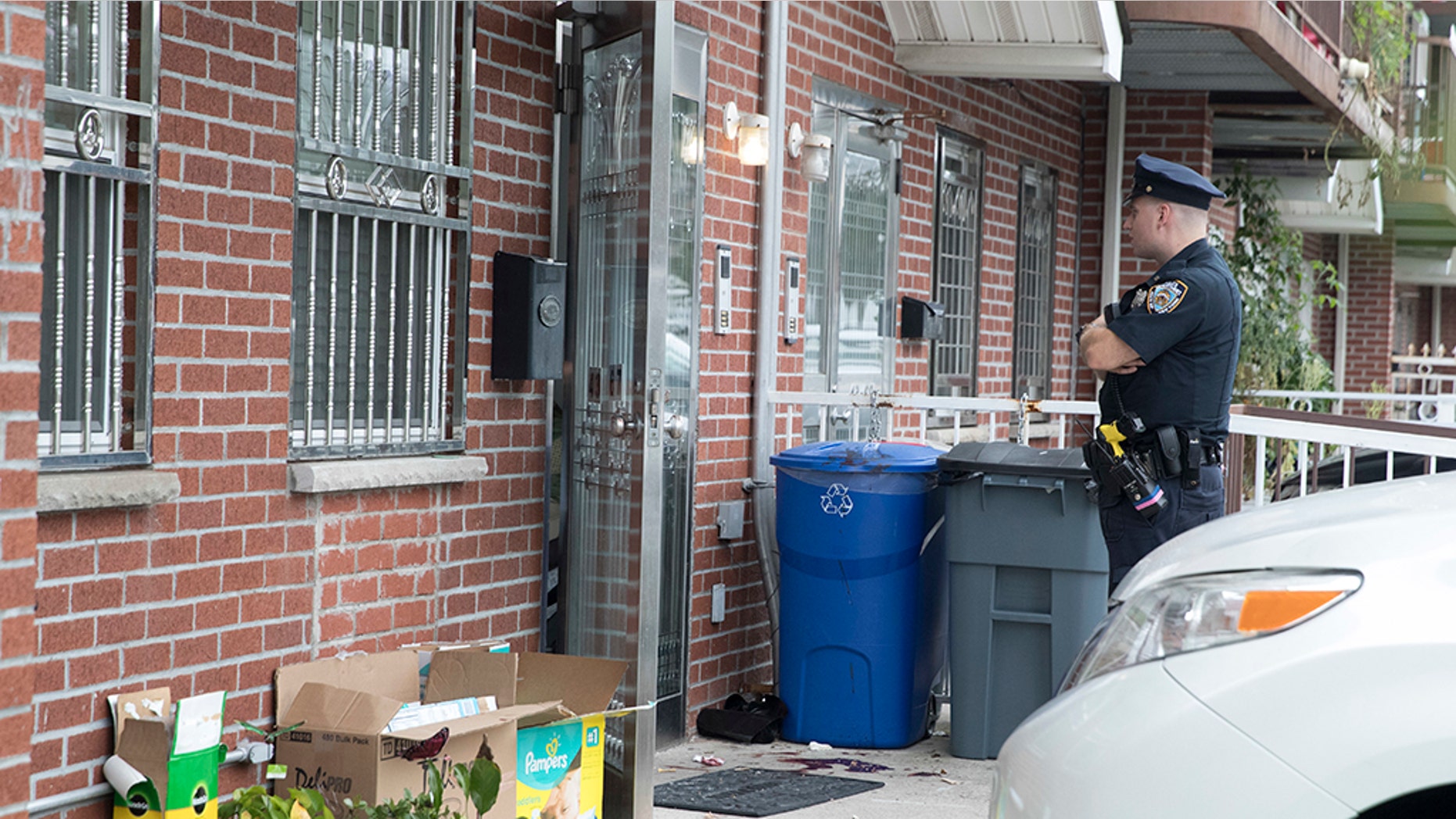 A police officer stands guard at the house were five people were stabbed overnight, Friday, Sept. 21, 2018, in New York.