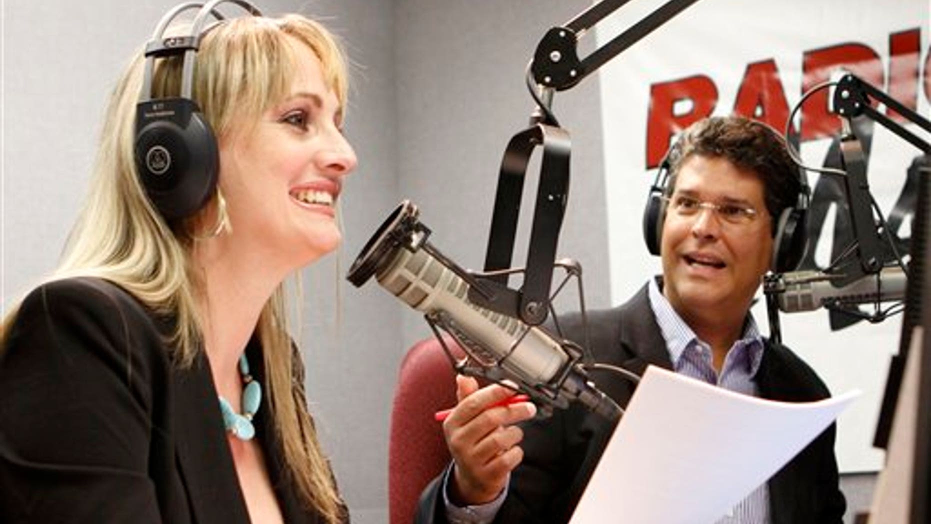 In this April 21, 2011 photo, Radio Marti's El Revoltillo, Spanish for The Scramble hosts Karen Caballero, left, and Alfredo Jacomino laugh during their radio show in Miami. A new radio show features Caballero and Jacomino, exchanging Regis & Kelly-like banter while reading off items and services for sale from a Cuban website. The program is more practical than political since few on the island have computer access. Based on nothing more than a Cuban-style Craigslist, it seems to work, mixing useful information with humor. (AP Photo/Alan Diaz)
