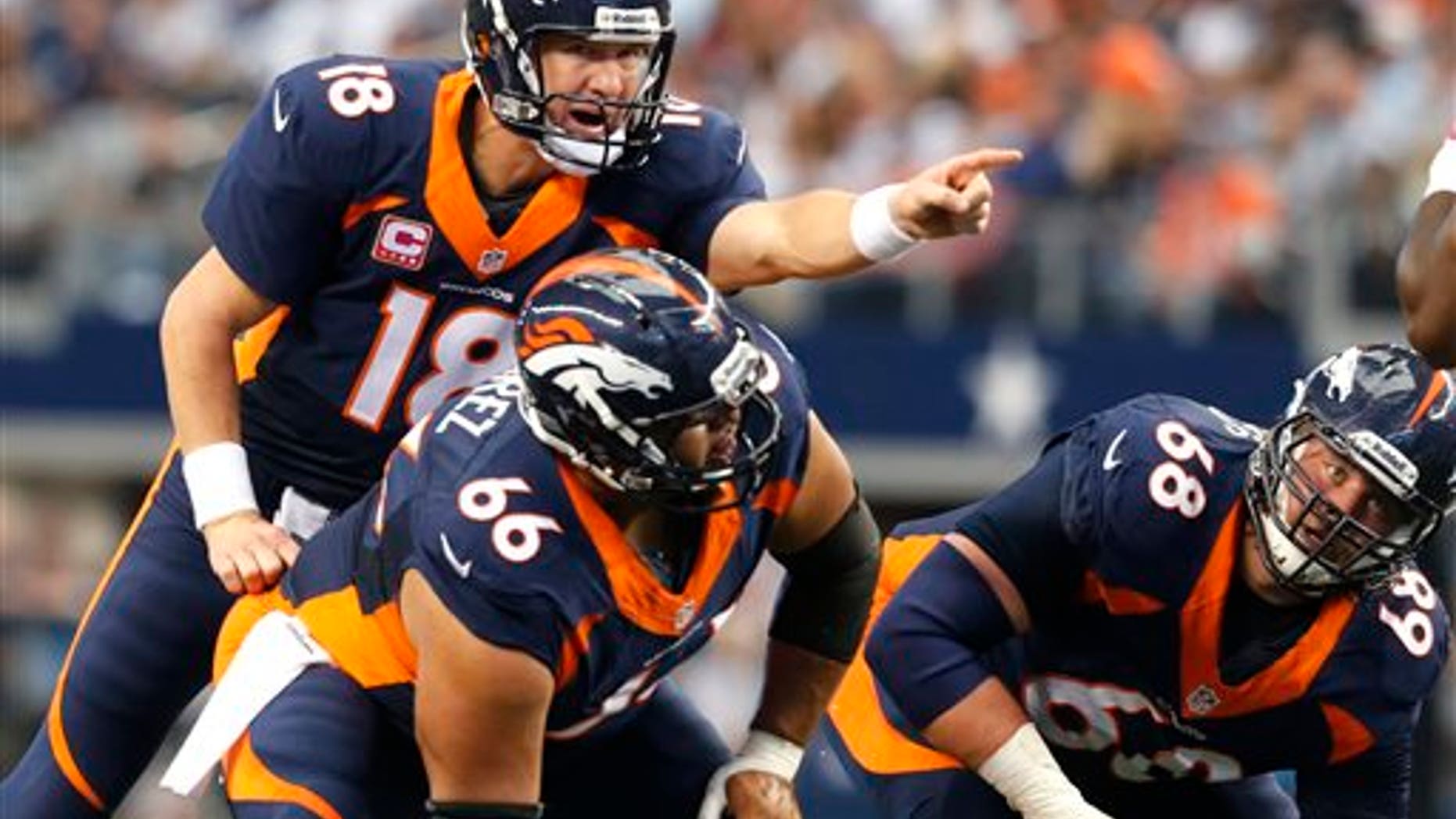 In this Oct. 6, 2013, photo, Denver Broncos quarterback Peyton Manning (18), center Manny Ramirez (66) and guard Zane Beadles (68) get ready for a play during an NFL football game against the Dallas Cowboys in Arlington, Texas. The man in the middle of Denver's offensive line, the one that's allowed the fewest sacks in the league, is the center who had never started a game at the position before this season. (AP Photo/Sharon Ellman)