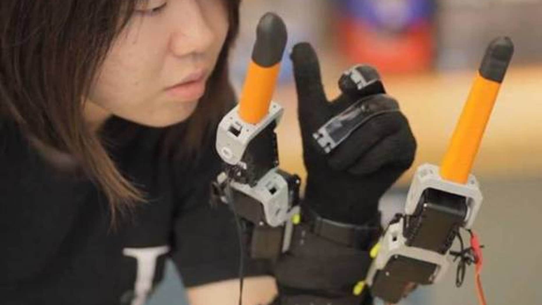 MIT graduate student, Faye Wu, demonstrates the new robotic device.