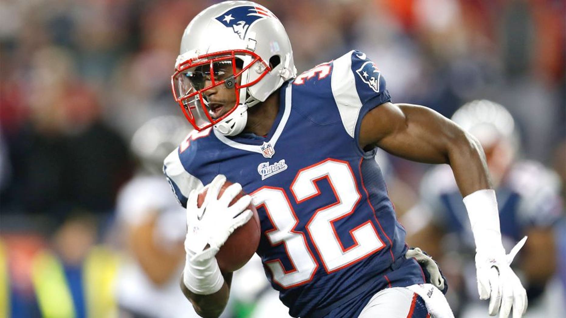 Jan 20, 2013; Foxboro, Massachusetts, USA; New England Patriots cornerback Devin McCourty (32) carries the ball during the fourth quarter against the Baltimore Ravens at Gillette Stadium. Mandatory Credit: Greg M. Cooper-USA TODAY Sports