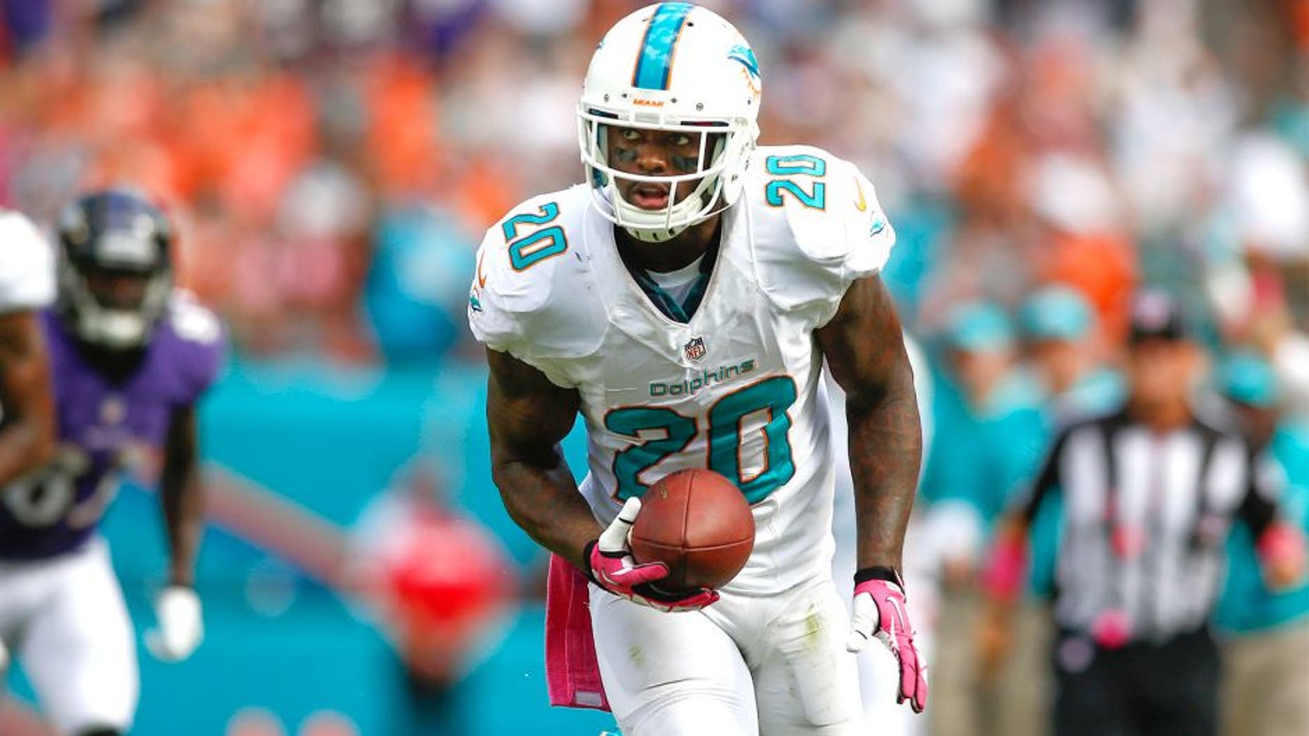 Oct 6, 2013; Miami Gardens, FL, USA; Miami Dolphins free safety Reshad Jones (20) returns am interception for a touchdown against the Baltimore Ravens in the second half at Sun Life Stadium. Mandatory Credit: Robert Mayer-USA TODAY Sports
