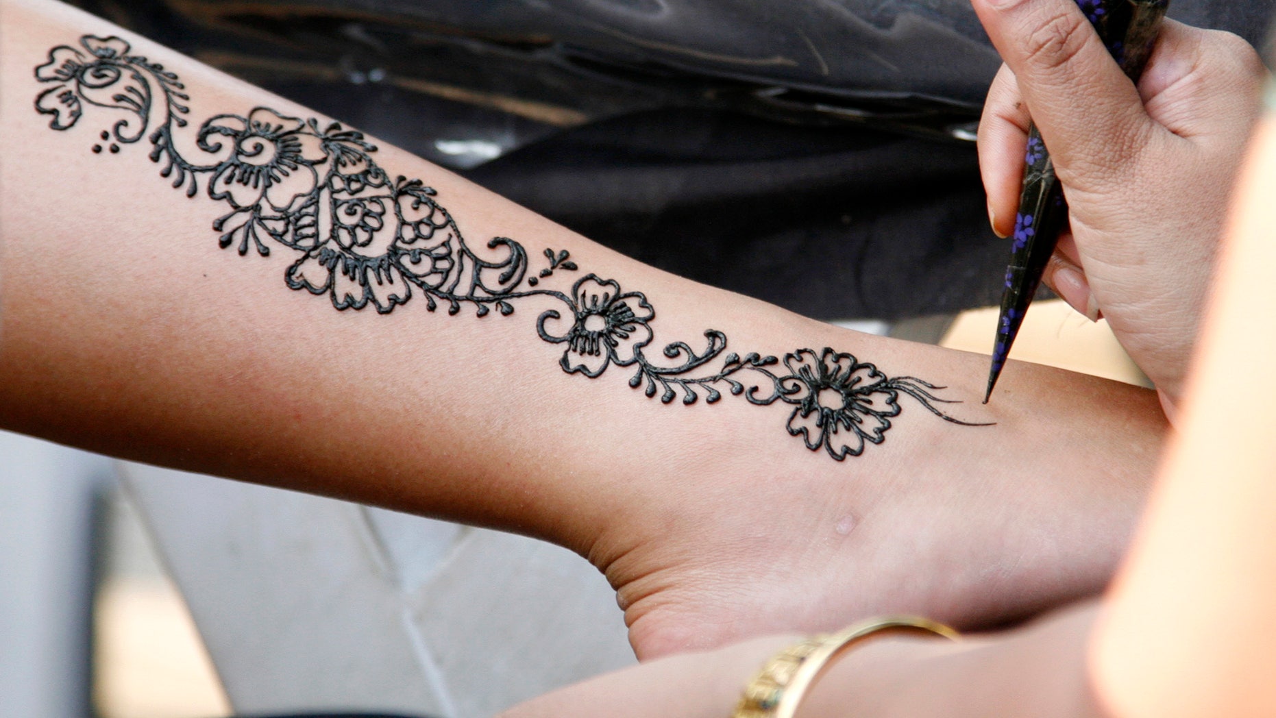 An artist demonstrates her skills with henna at a showcase of tattoo art during the Singapore Art Show 2007. (REUTERS/Rob Dawson)
