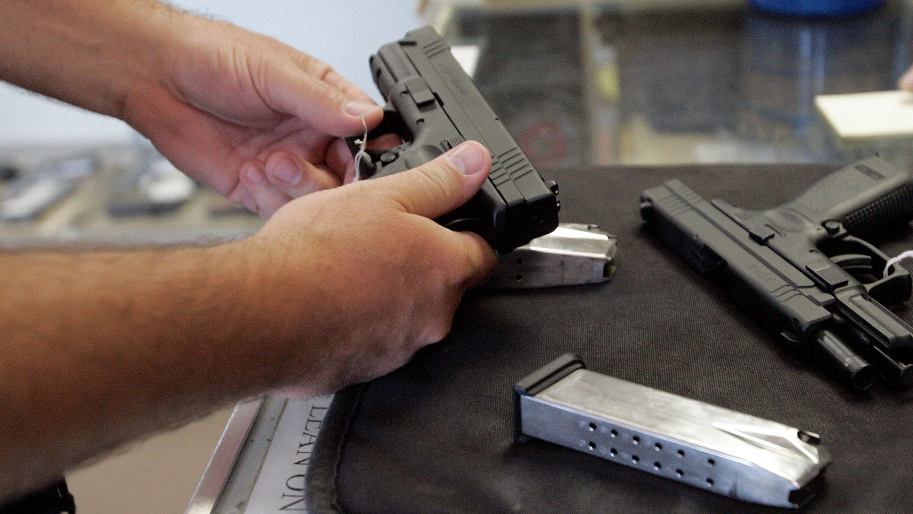 June 26, 2008 file A customer inspects a 9mm handgun at Rink's Gun and Sport in the Chicago, suburb of Lockport, Illinois