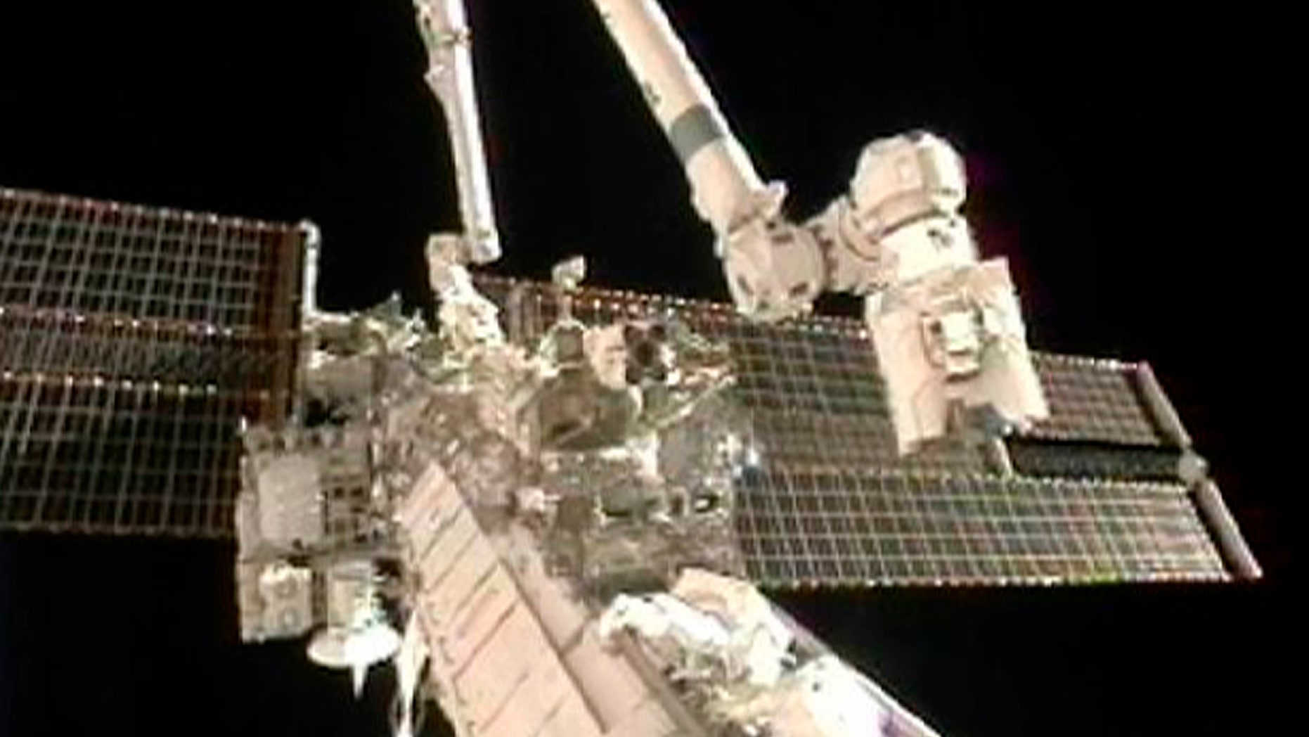 Doug Wheelock (top) and Tracy Caldwell Dyson work to remove a faulty ammonia pump module on the exterior of the International Space Station during their spacewalk in this image from NASA TV August 7, 2010. REUTERS/NASA TV (UNITED STATES) EDITORIAL USE ONLY NOT FOR USE IN ADVERTISING OR MARKETING CAMPAIGNS (SCI TECH SOCIETY) FOR EDITORIAL USE ONLY. NOT FOR SALE FOR MARKETING OR ADVERTISING CAMPAIGNS