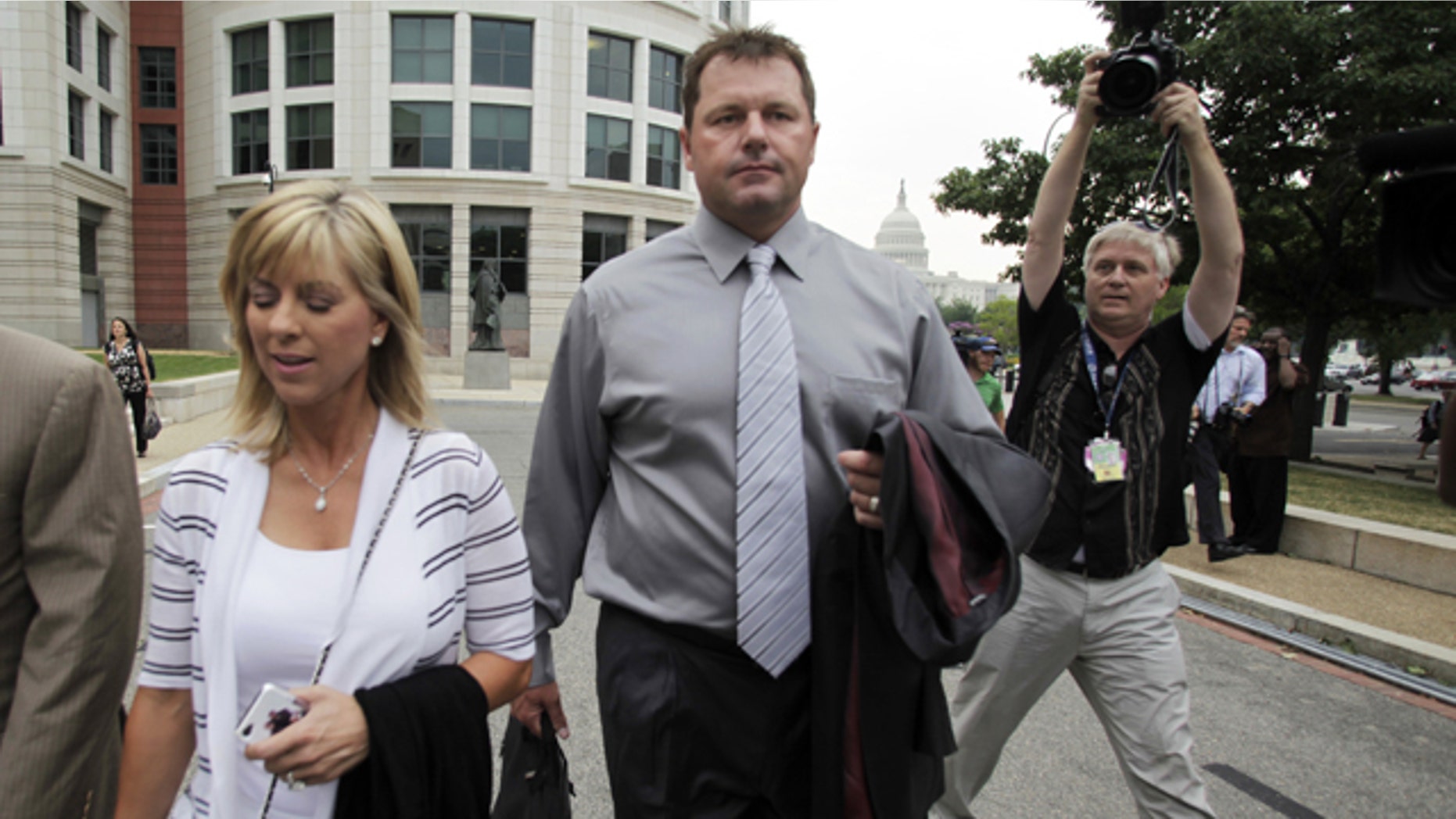 July 6, 2011: Former Major League Baseball pitcher Roger Clemens arrives, with his wife Debbie, for the first day of his perjury trial, at the federal courthouse in Washington.