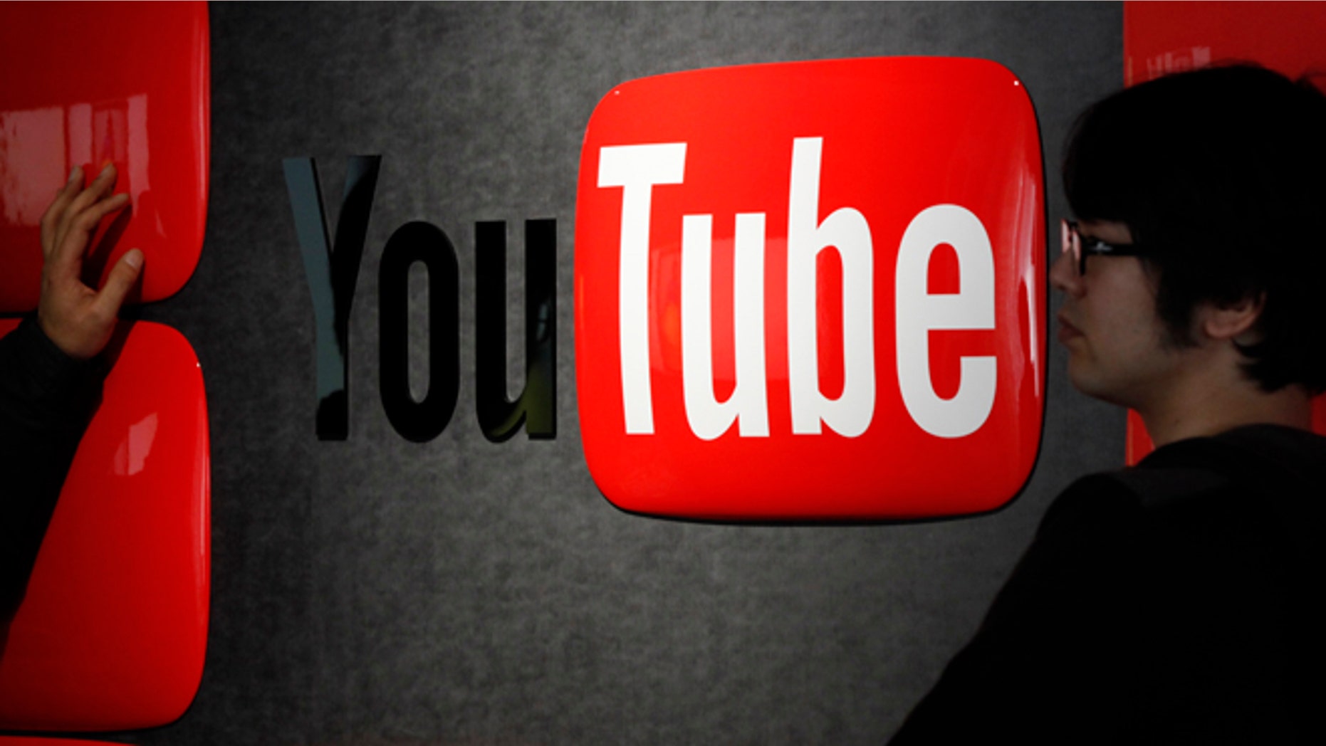 Feb. 14, 2013: Visitors stand in front of a logo of YouTube at the YouTube Space Tokyo, operated by Google, in Tokyo.