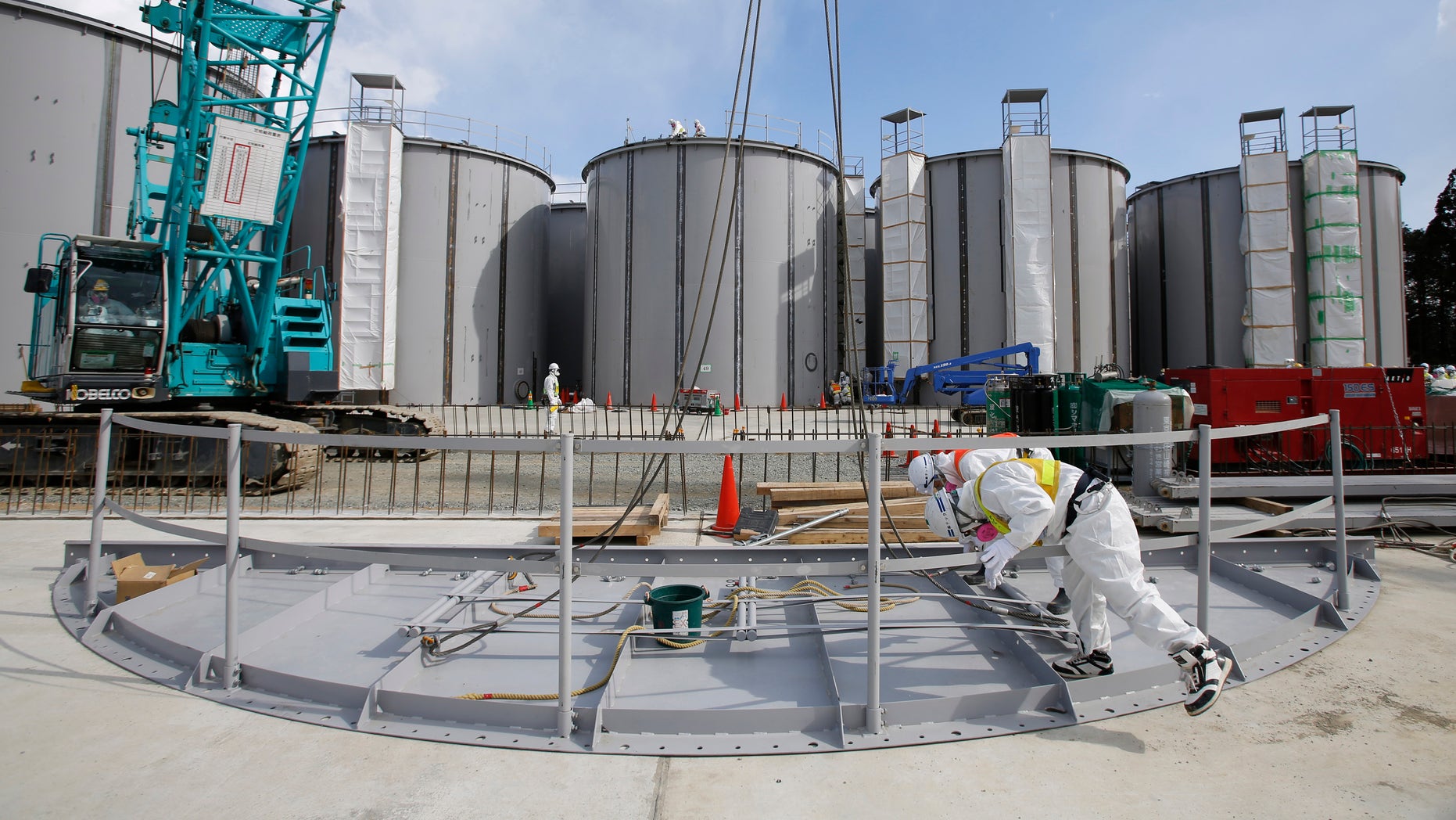 March 10, 2014 - FILE photo of men wearing protective suits and masks work in front of welding storage tanks for radioactive water, under construction at TEPCO's tsunami-crippled Fukushima Daiichi nuclear power plant in Fukushima prefecture, Japan.